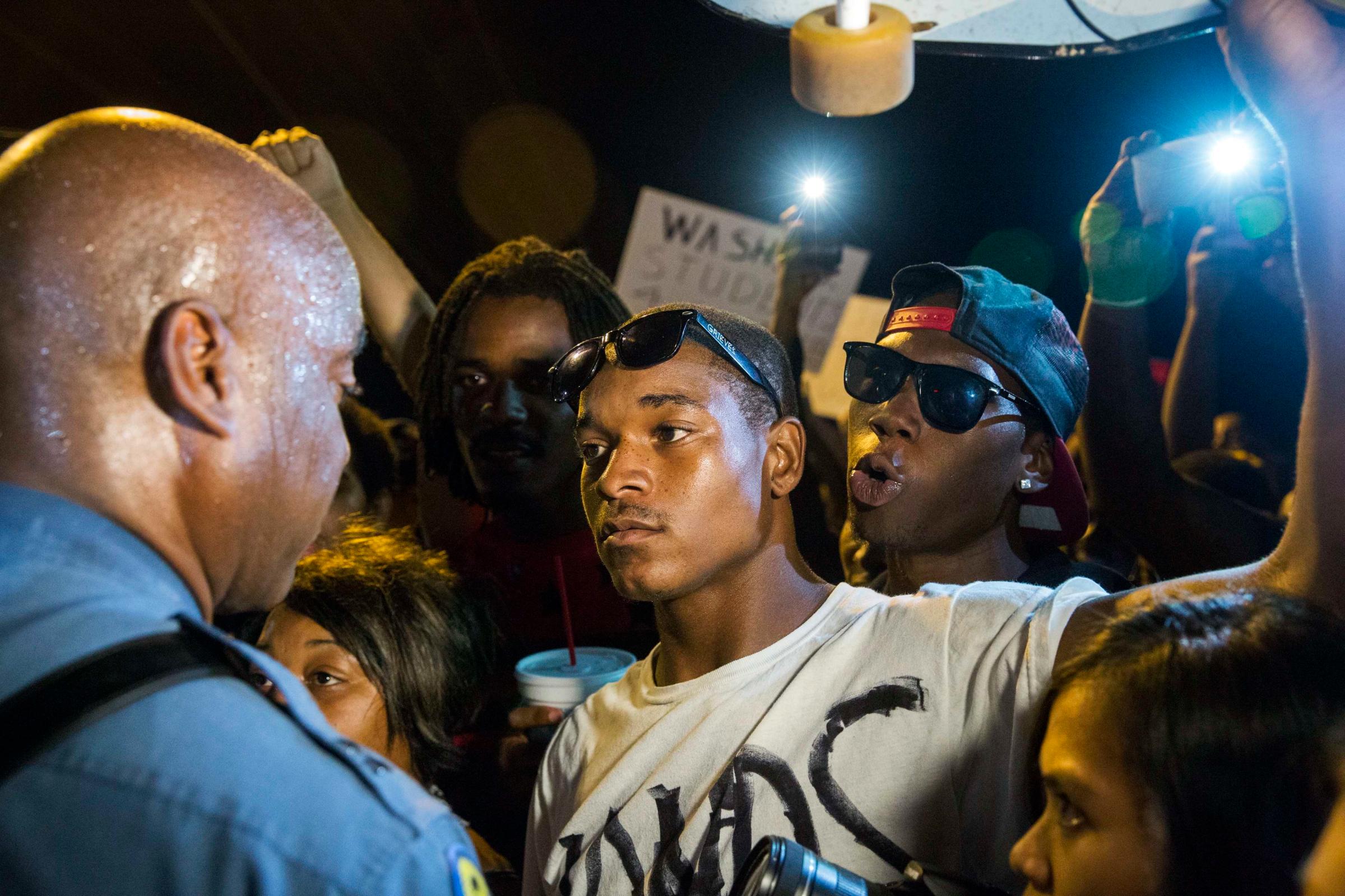 Missouri State Highway Patrol Captain Ron Johnson speaks to protesters as he walks through a peaceful demonstration as communities continue to react to the shooting of Michael Brown in Ferguson