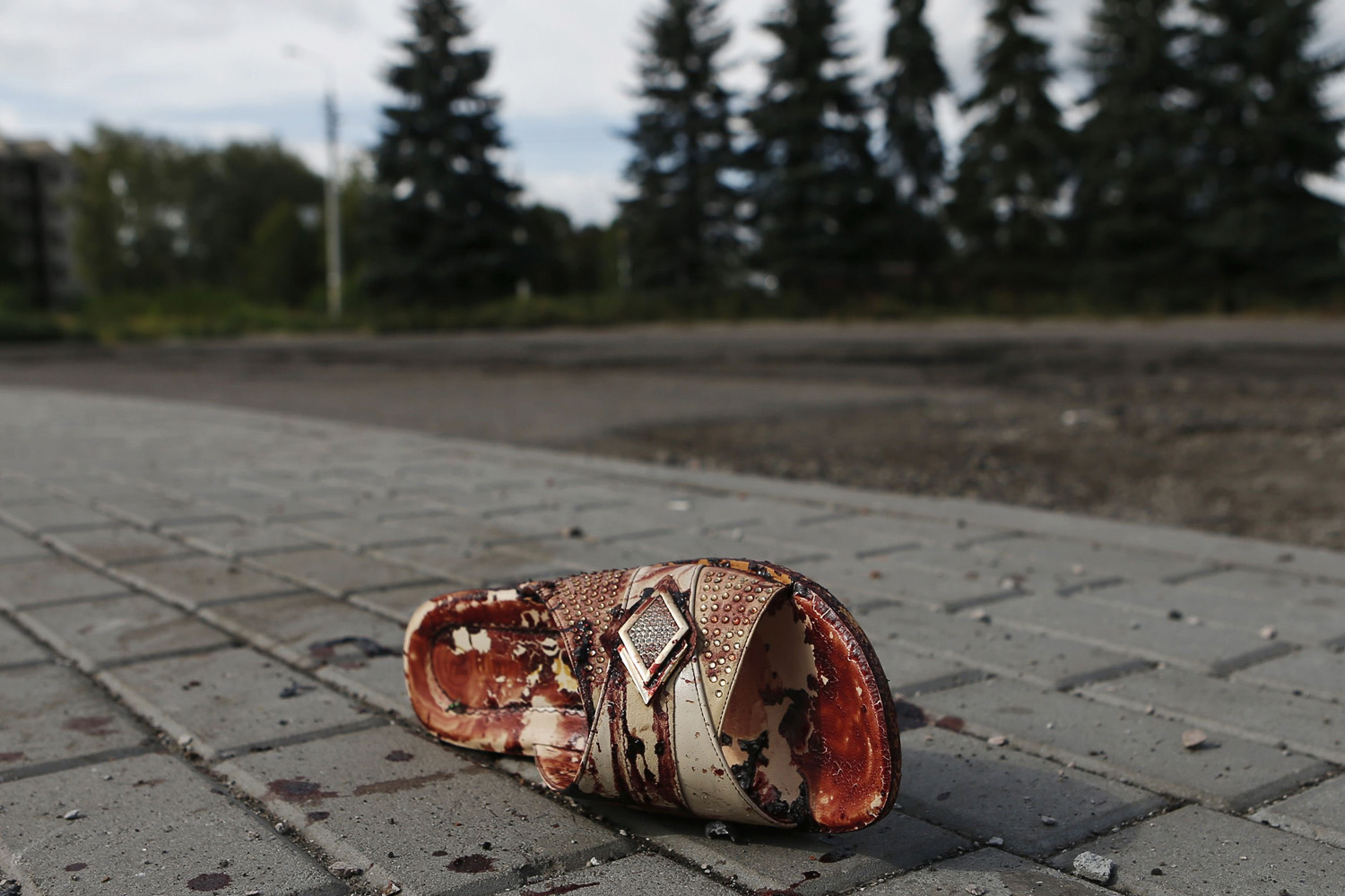 A slipper lies near bloodstains on street after recent shelling in settlement of Makiivka, on outskirts of Donetsk