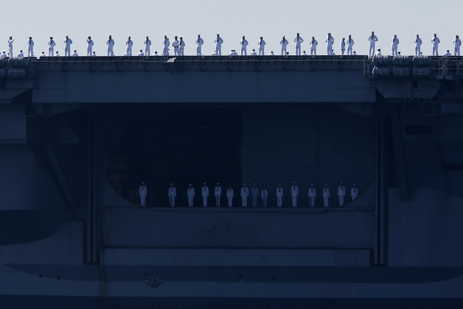 Sailors man the rails of the USS Carl Vinson, a Nimitz-class aircraft carrier, as it departs its home port in San Diego, California
