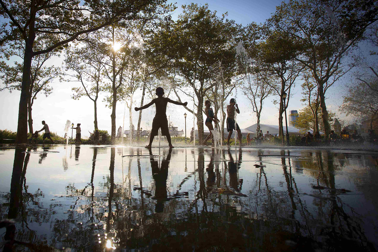 Children play in a fountain in the late afternoon sun in the Lower Manhattan borough of New York City on Aug. 25, 2014.