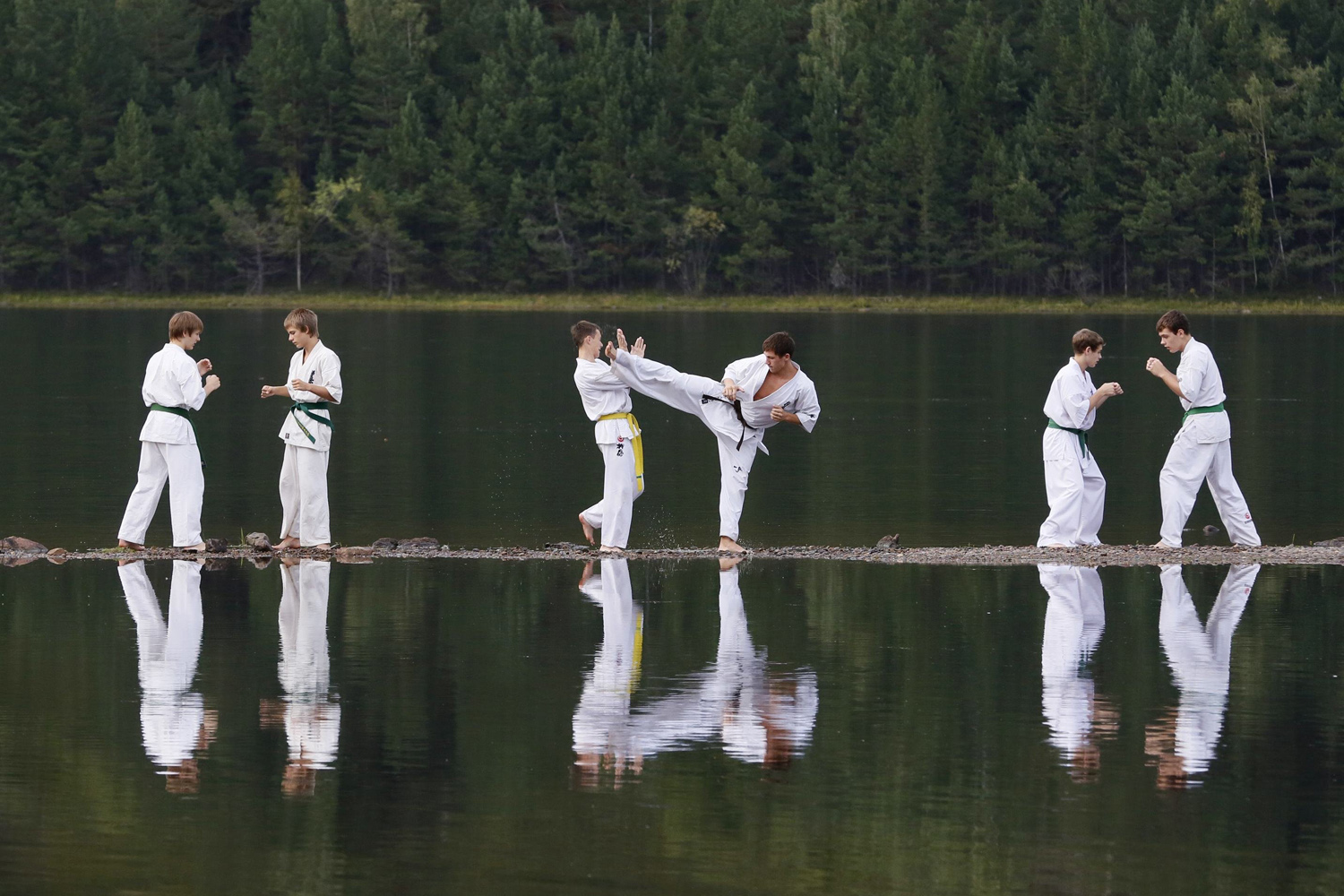 Young members of a local Kyokushin Karate federation perform during an exercise session at a summer training camp on a bank of the Yenisei River near the town of Divnogorsk, Siberia, Aug. 26, 2014.