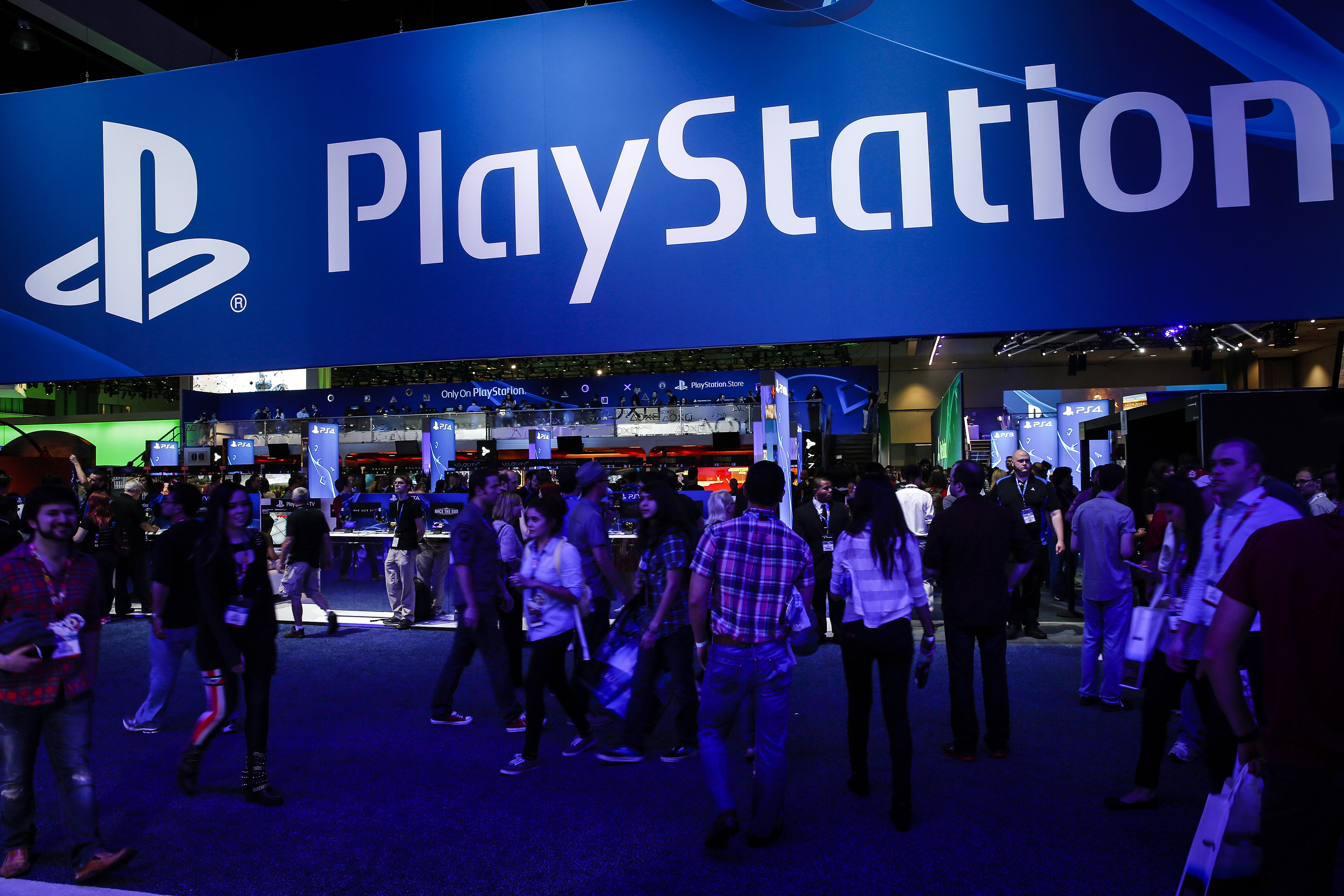 Attendees walk past the Sony Corp. PlayStation booth during the E3 Electronic Entertainment Expo in Los Angeles, California, U.S. on Tuesday, June 10, 2014. (Patrick T. Fallon/Bloomberg via Getty Images)