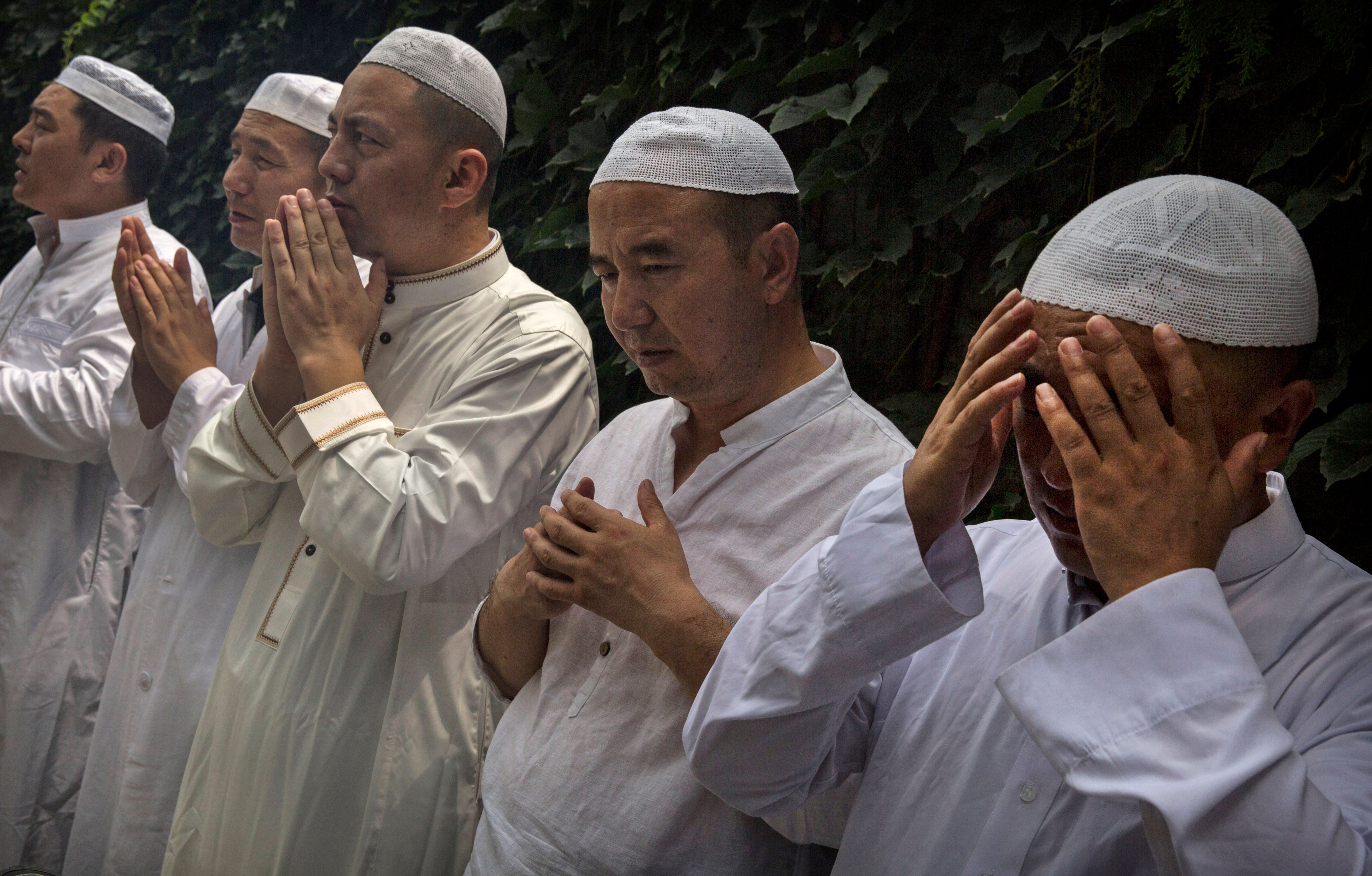 Hui imams pray before the main Friday prayers during the holy fasting month of Ramadan at the historic Niujie Mosque in Beijing on July 4, 2014 (Kevin Frayer—Getty Images)