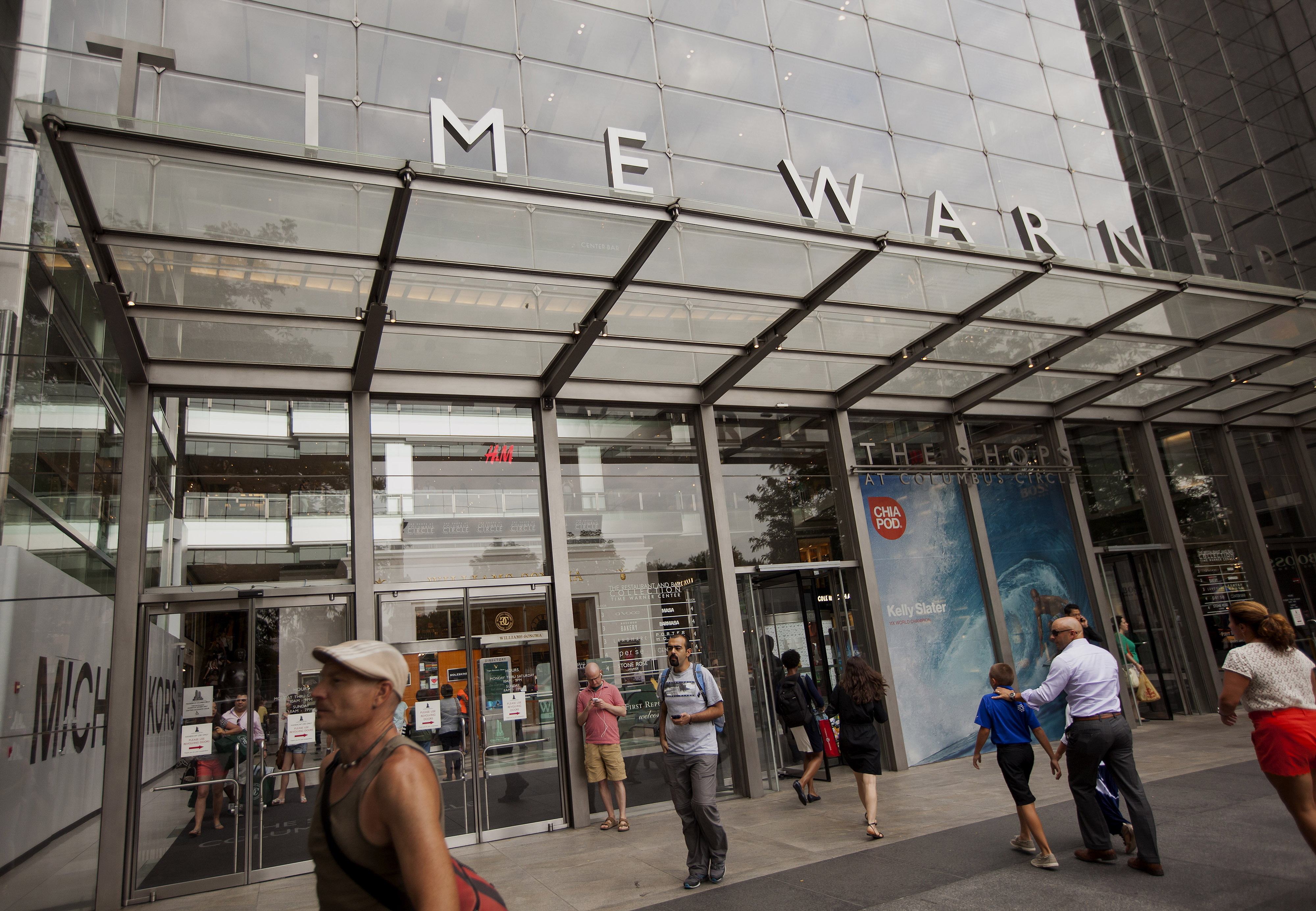Pedestrians walk past the Time Warner Center in New York, U.S., on Monday, July 21, 2014. (Bloomberg—Bloomberg via Getty Images)