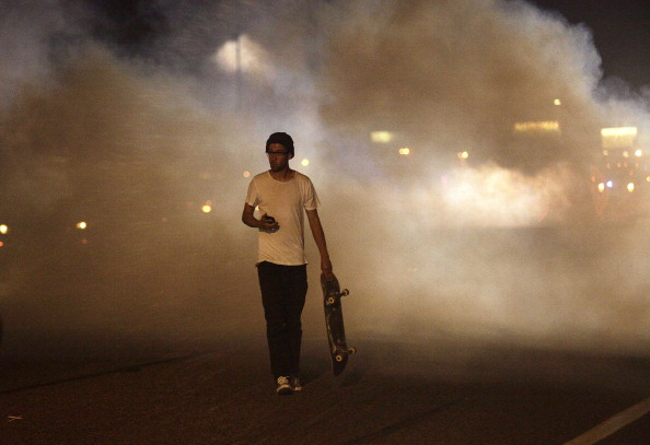 A man with a skateboard protesting the shooting of Michael Brown by a police officer walks away from tear gas released by police August 17, 2014 in Ferguson, Missouri. (Joshua Lott—Getty Images)