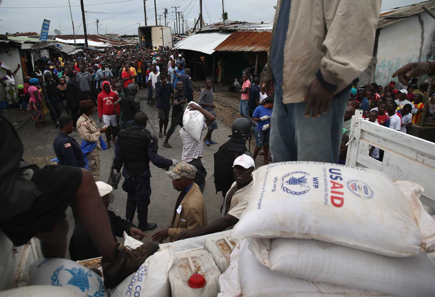 Residents of the West Point slum receive food aid during the second day of the government's Ebola quarantine on their neighborhood on August 21, 2014 in Monrovia, Liberia. (John Moore—Getty)