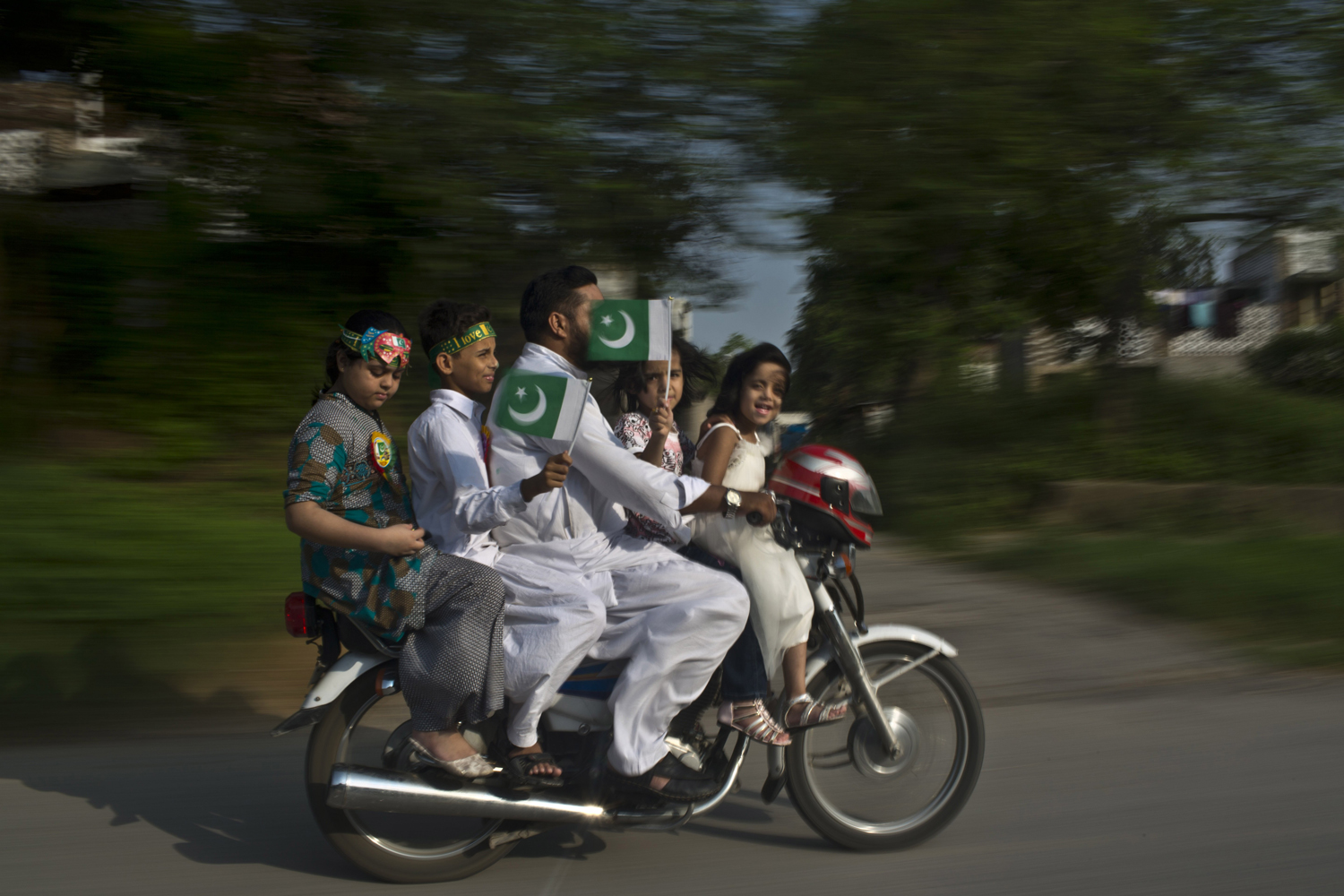 Aug. 14, 2014. A Pakistani father and his four children, ride a motorcycle along a road, and waving their national flag, as they celebrate the 68th Independence Day, in Islamabad, Pakistan.