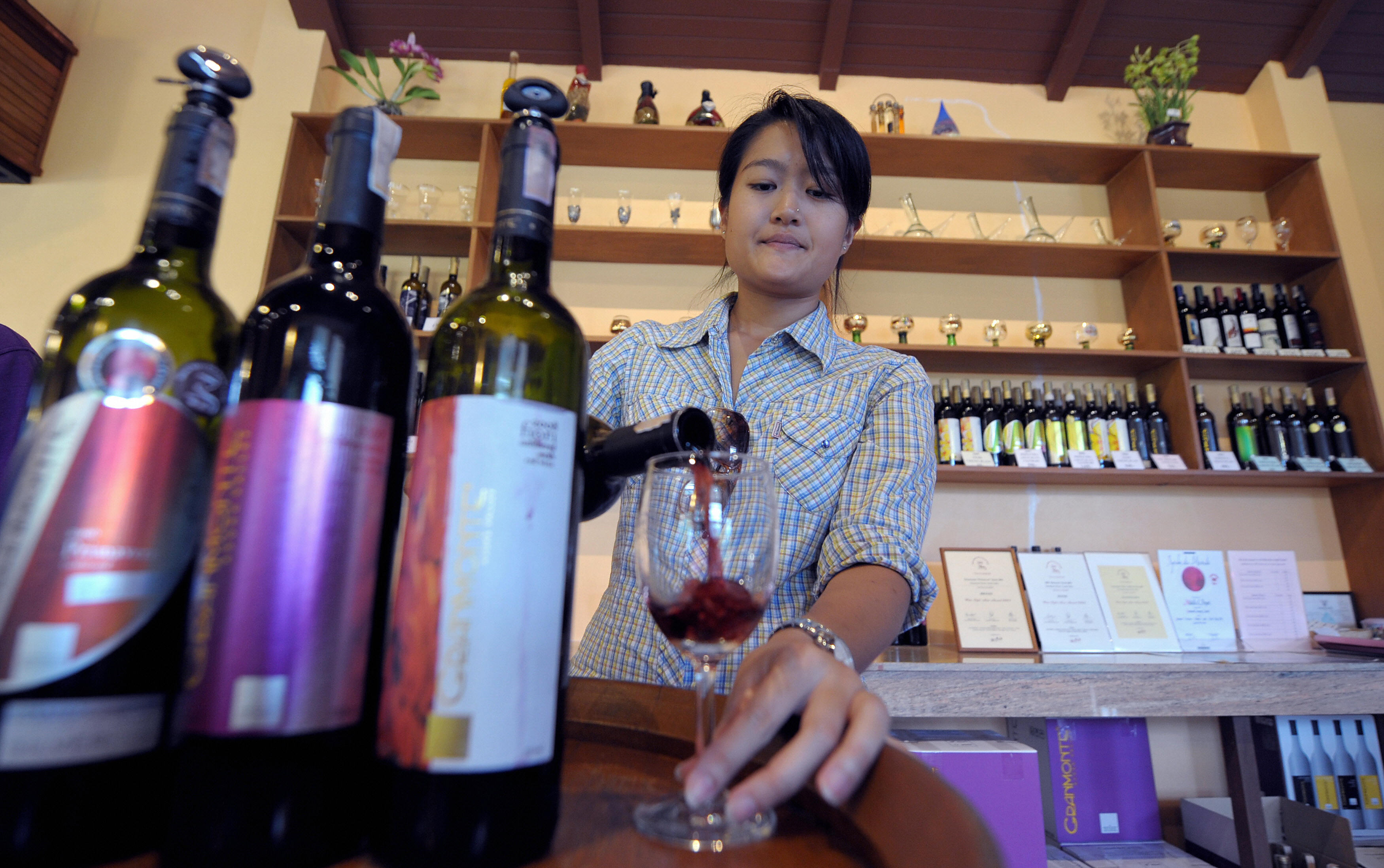 In a picture taken on July 6, 2009, Nikki Lohitnavy, Thailand's first female winemaker tests her wine at a wineshop in Khao Yai National Park 155km (96 miles) north of Bangkok. (PORNCHAI KITTIWONGSAKUL—AFP/Getty Images)