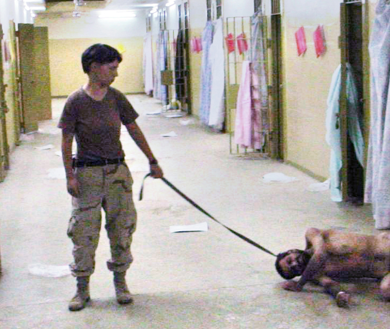 U.S. Army Spc. Lynndie England with a naked detainee at the Abu Ghraib prison in Baghdad, Iraq. Date unknown.