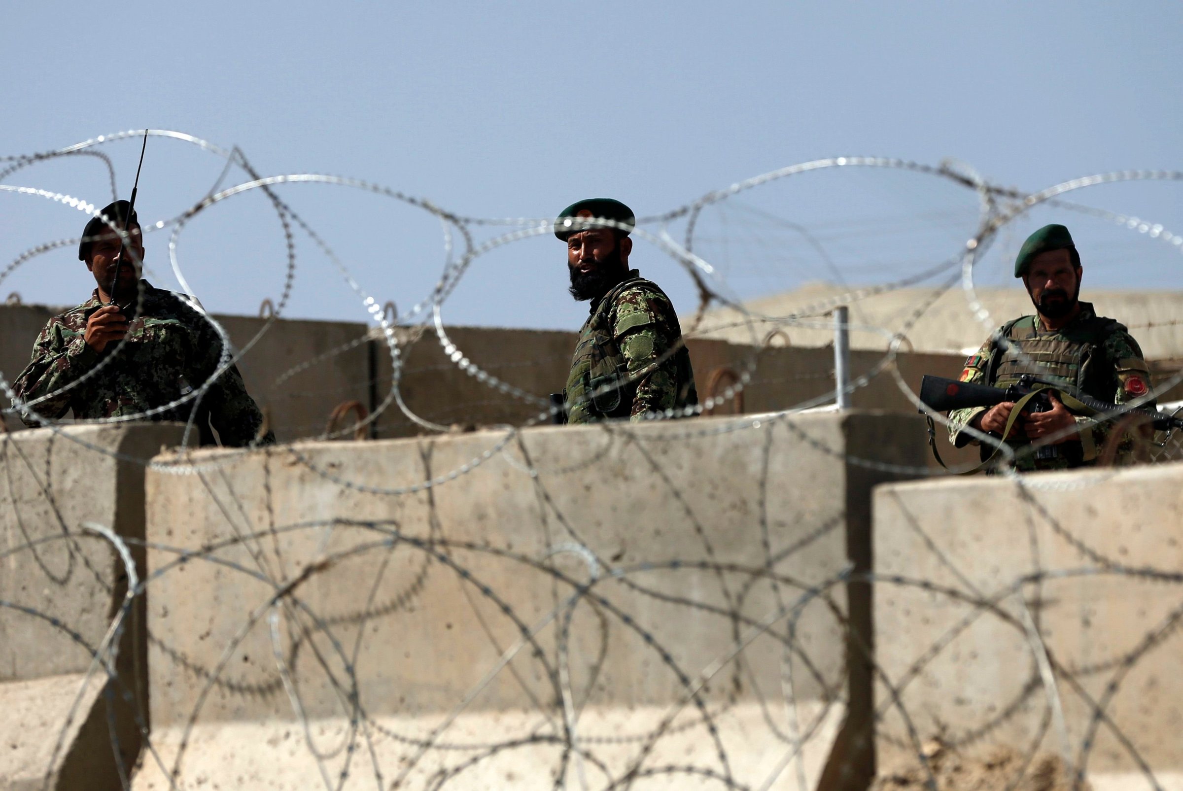 Afghan National Army soldiers keep watch at the gate of a British-run military training academy Camp Qargha, in Kabul on August 5, 2014.