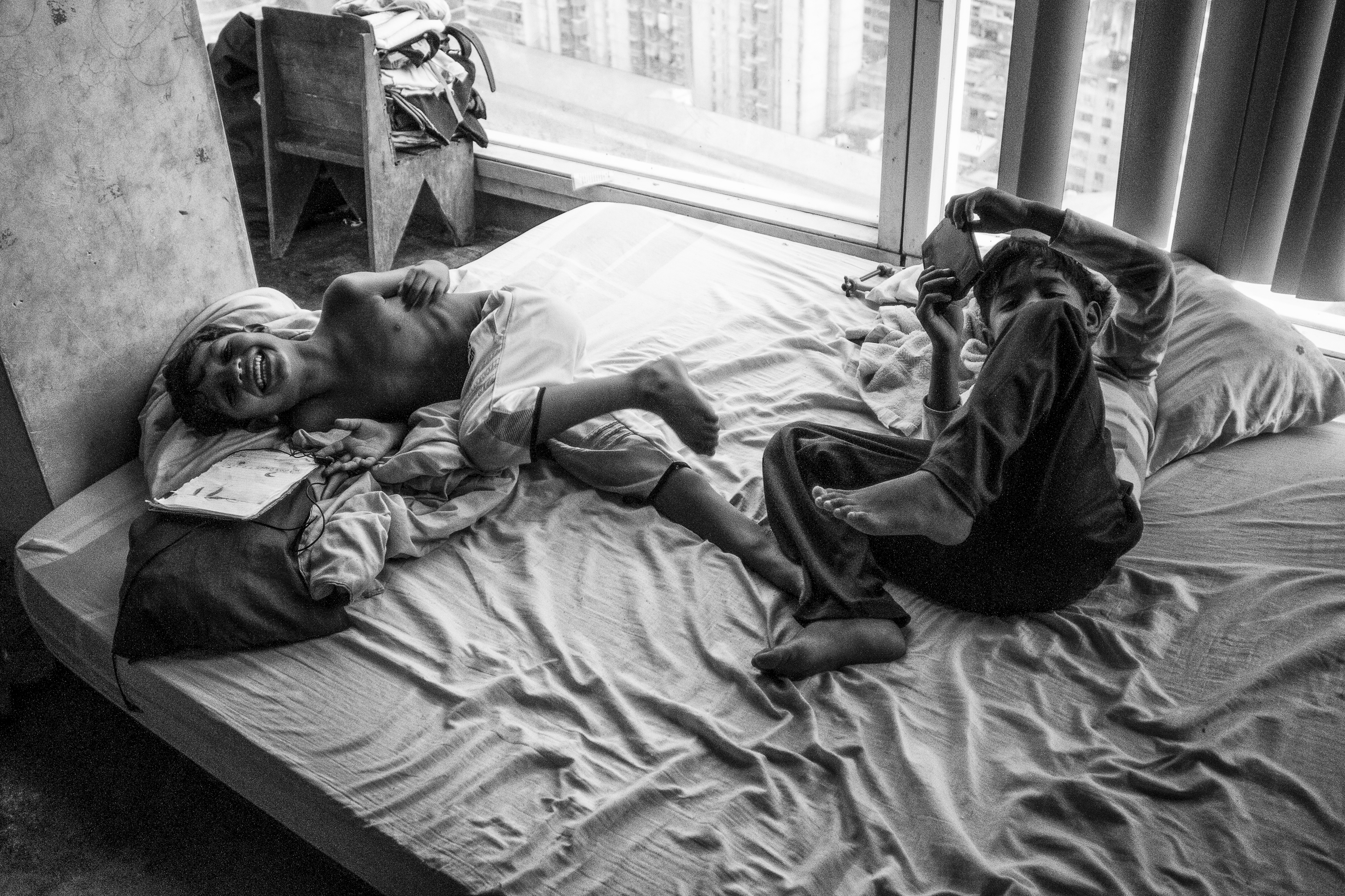 Two boys play on their bed while watching television, children are not always fully aware of where they live