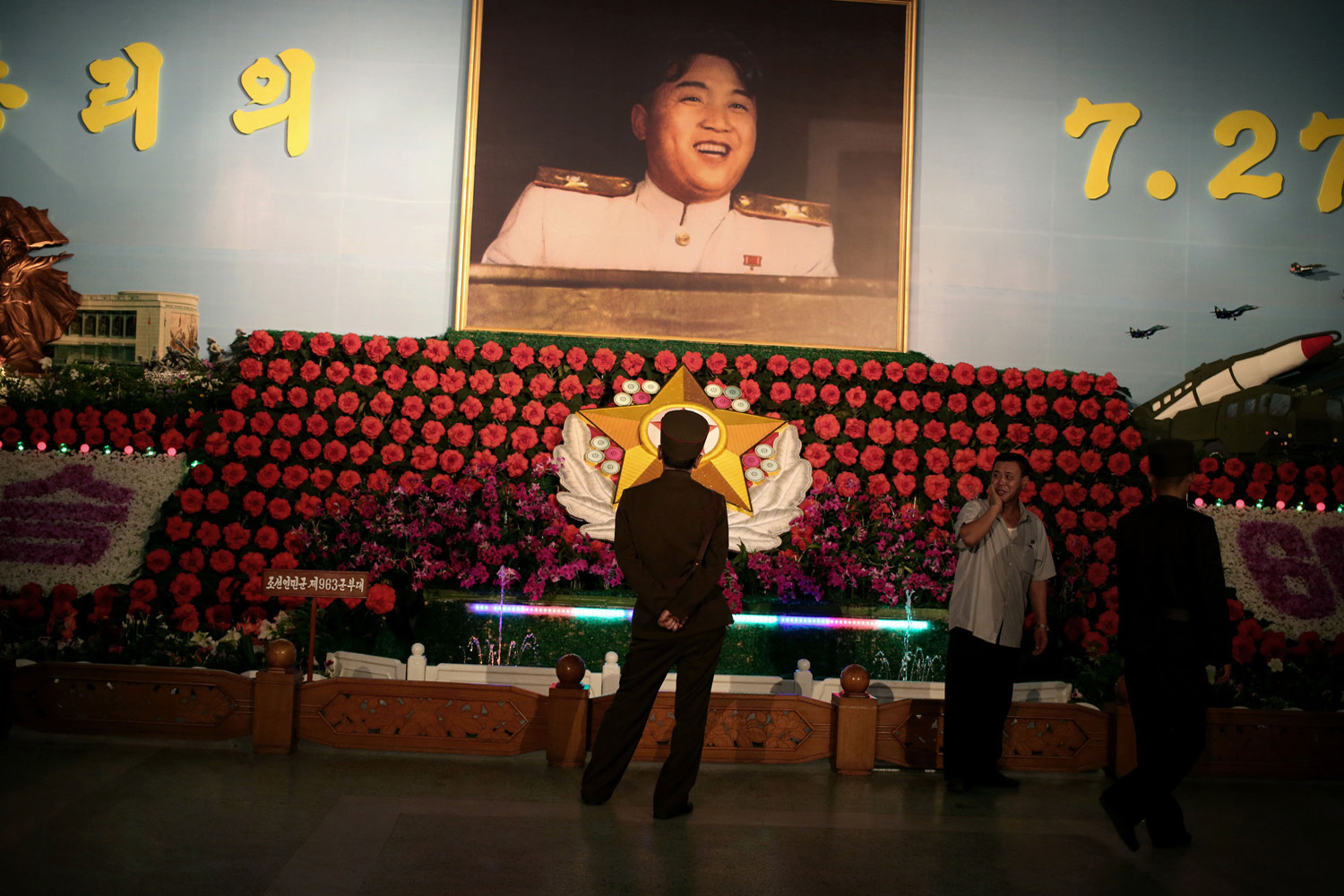 A soldier looks at flowers, named Kimjongilia and Kimilsungia after Kim Jong Il and Kim Il Sung, respectively, which are on display in Pyongyang, Jul. 24, 2013.