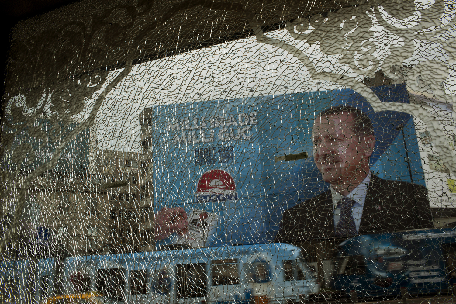 Aug. 8, 2014. A poster of Prime Minister and presidential candidate in Turkeyís Aug. 10 presidential election, Recep Tayyip Erdogan is seen through the broken glass of a nearby shop in downtown Istanbul, Turkey.