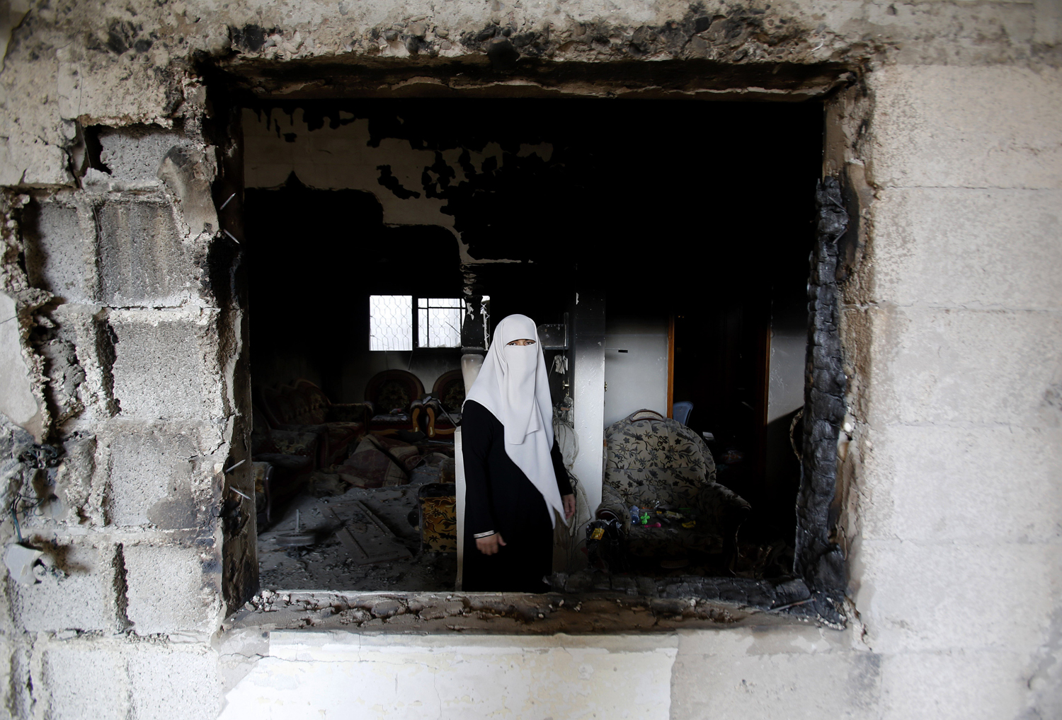 Aug. 11, 2014. A Palestinian woman stands in the rubble of her destroyed home in Gaza City's Shijaiyah neighborhood.