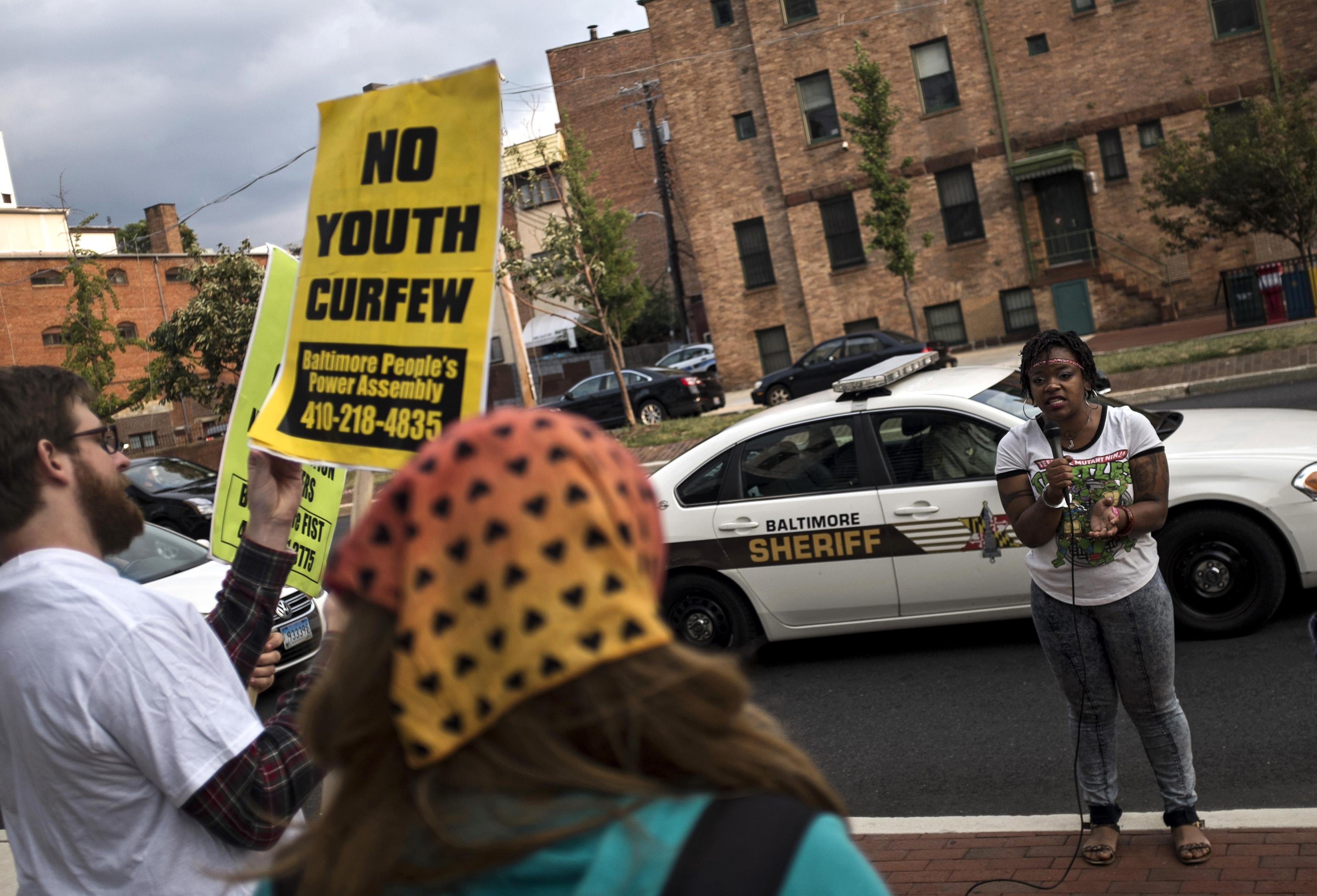 Protesters demonstrate before community meeting with city officials about new youth curfew legislation in Baltimore