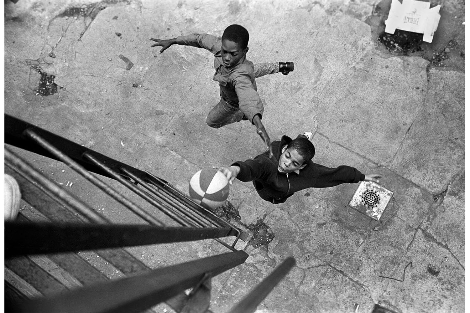 From Stephen Shames' Bronx Boys,  published by the University of Texas PressBoys play basketball, using the fireescape ladder at the hoop. 1987 - 88