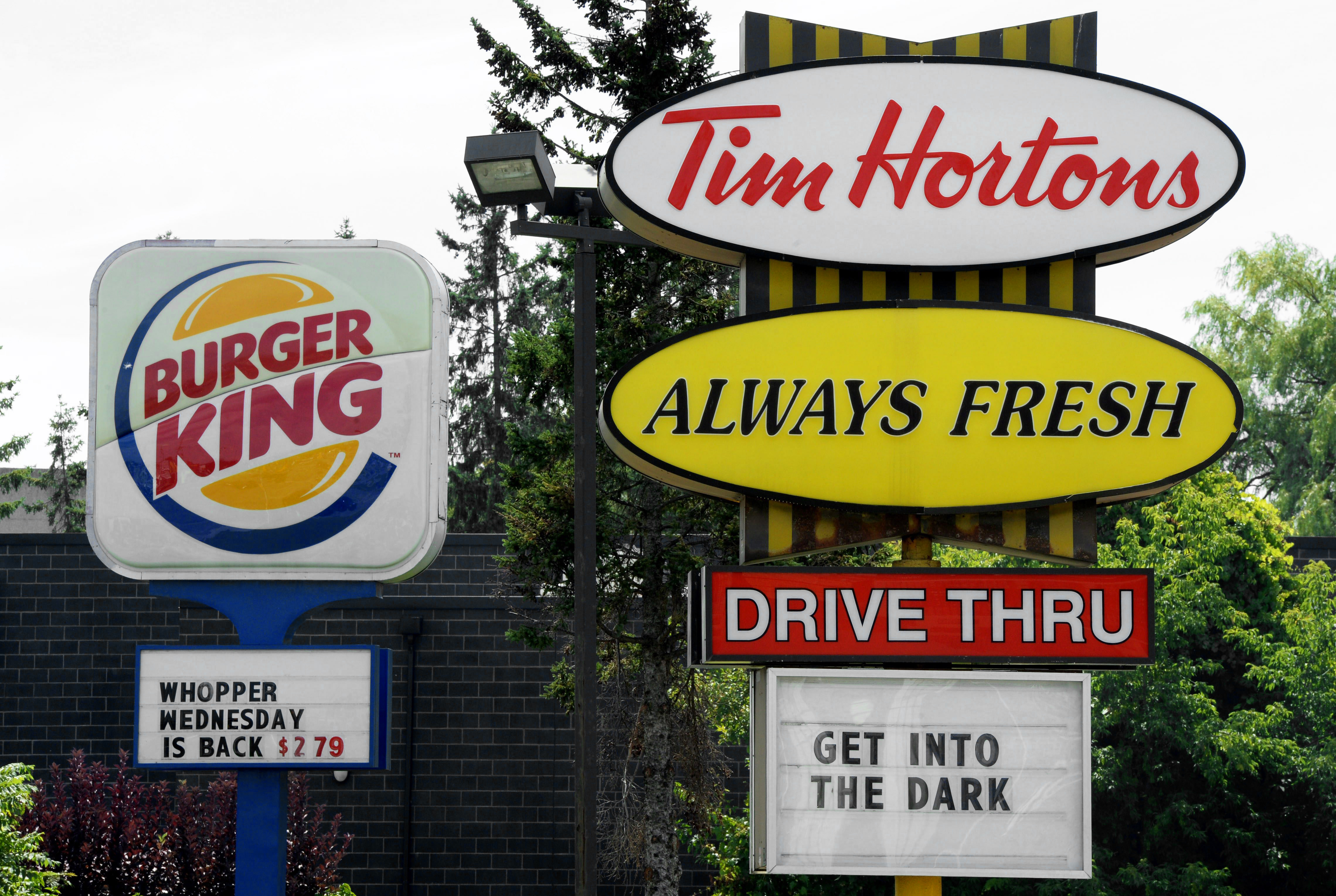 A Burger King sign and a Tim Hortons sign are displayed on St. Laurent Boulevard in Ottawa, Canada on Aug. 25, 2014. 