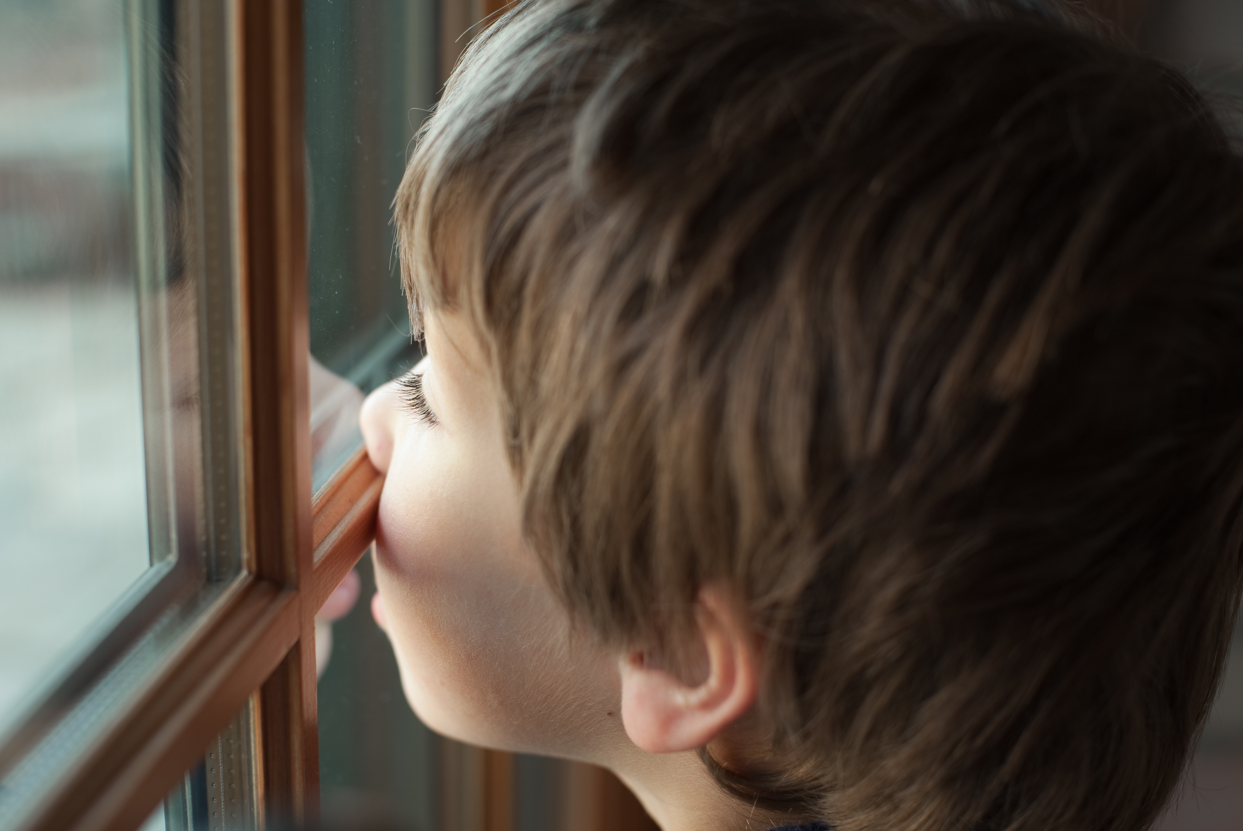 Boy presses his nose against window
