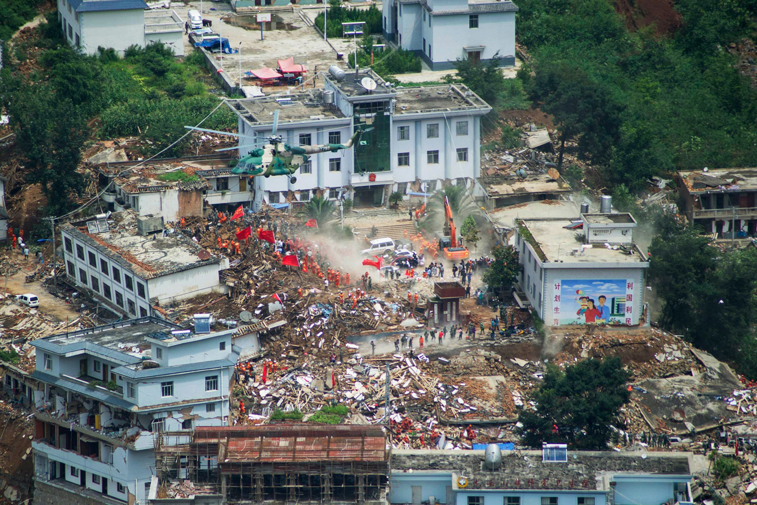 A helicopter flies above collapsed houses after a magnitude 6.3 earthquake hit Longtoushan town, Ludian county, Zhaotong, Yunnan province on Aug. 4, 2014.