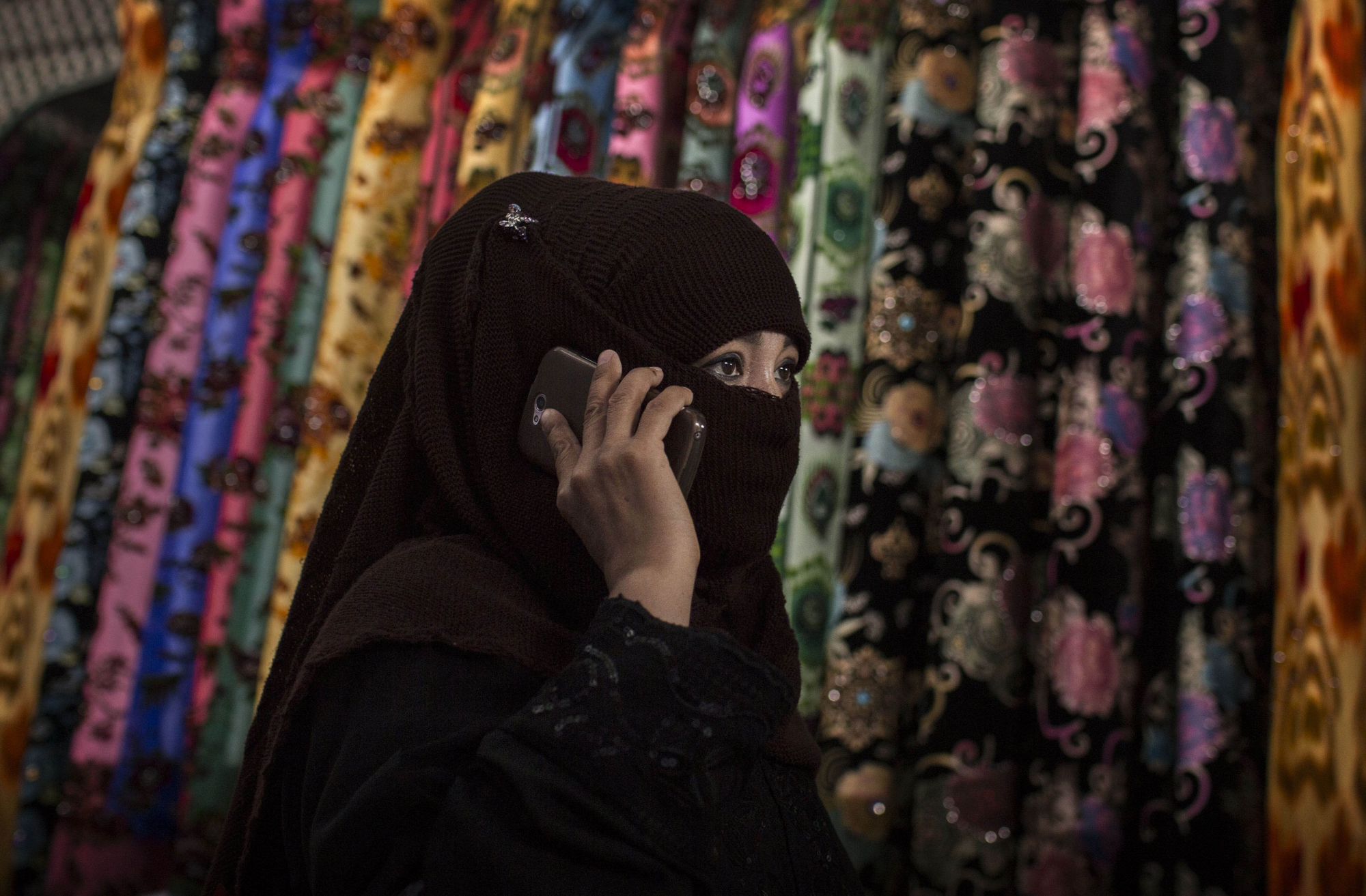 A Uyghur woman wears a veil as she shops at a local market on August 2, 2014 in Kashgar.