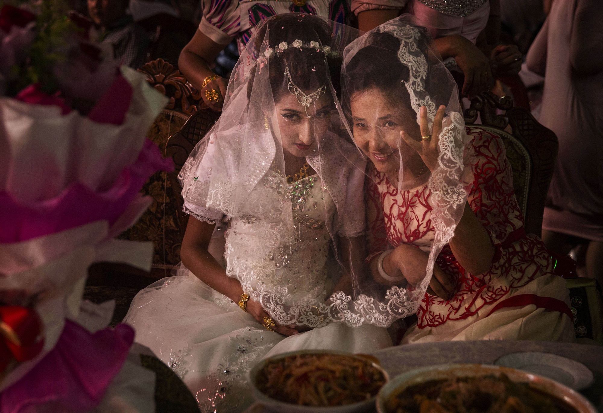 A Uyghur bride talks with a friend at her wedding celebration on August 2, 2014 in Kashgar.