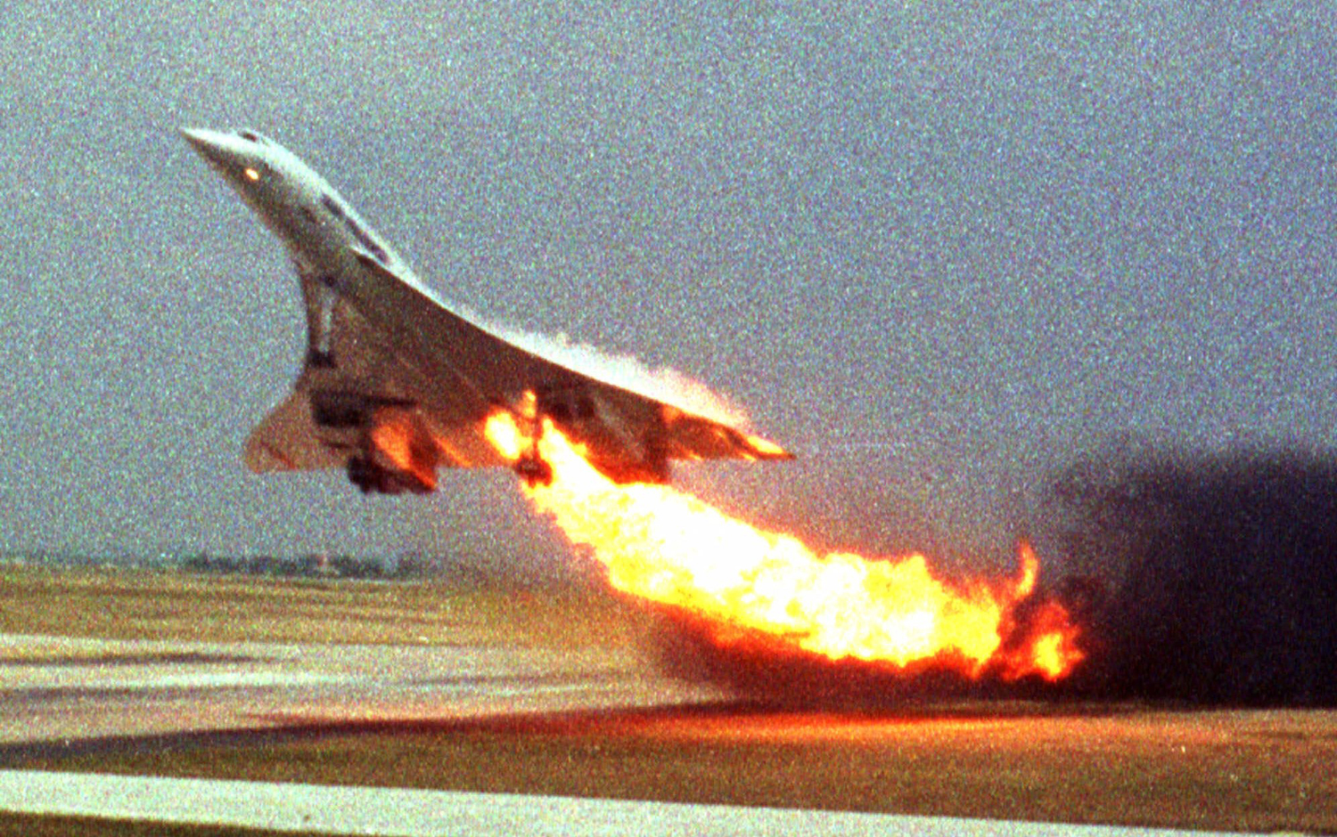 Air France Concorde flight 4590 takes off with fire trailing from its engine on the left wing from Charles de Gaulle airport in Paris on July 25, 2000. The plane crashed shortly after take-off, killing all the 109 people aboard and four others on the ground. A Japanese businessman Toshihiko Sato took this photo from inside another plane.