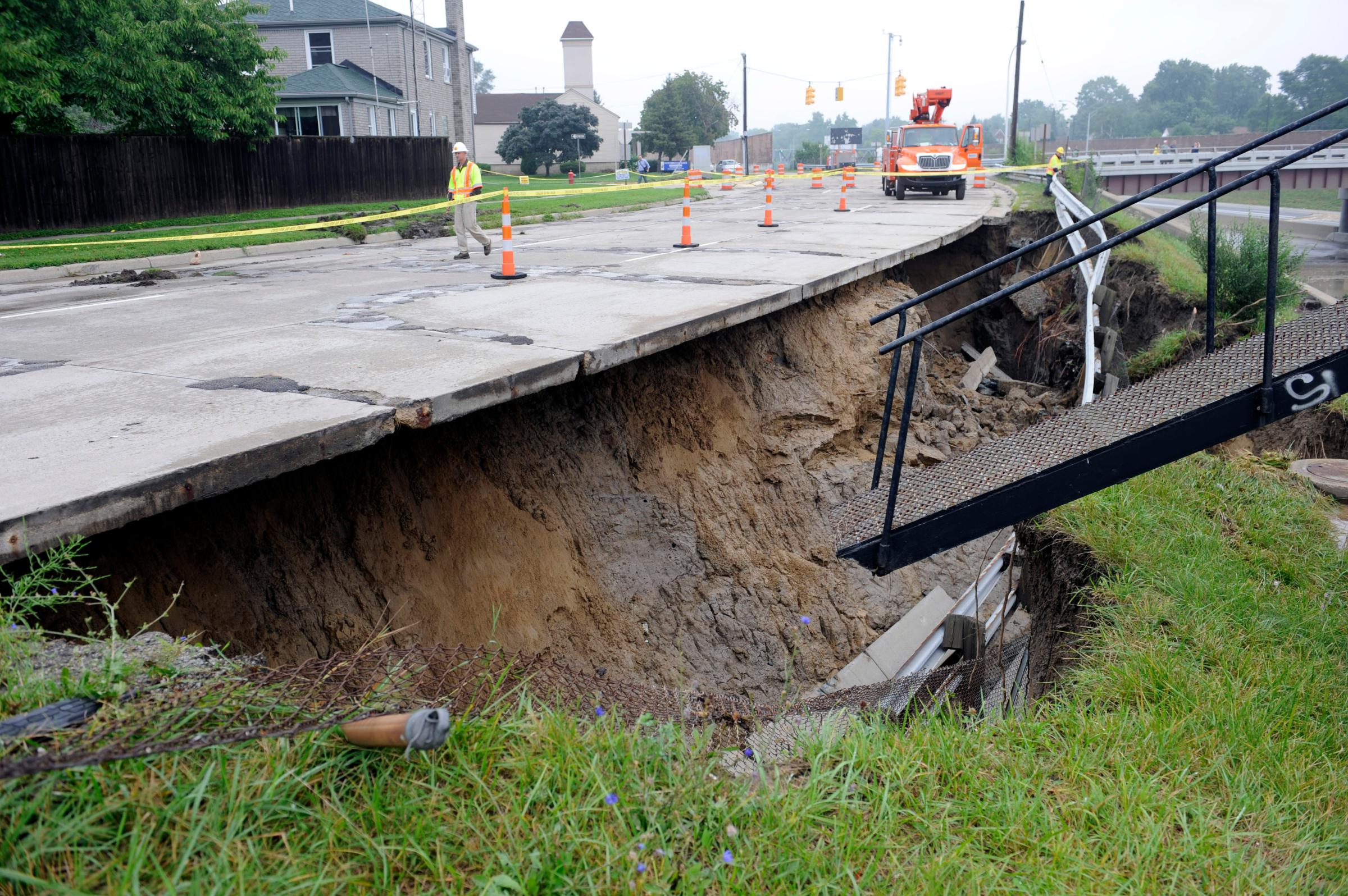 The west service drive of I-75 is washed out under the roadway in Madison Heights, Mich. on Aug. 12, 2014. Fearing more motorists could become stranded a day after a storm dumped more than 6 inches of rain in some places in and around Detroit, the state warned commuters against driving in affected areas Tuesday morning.