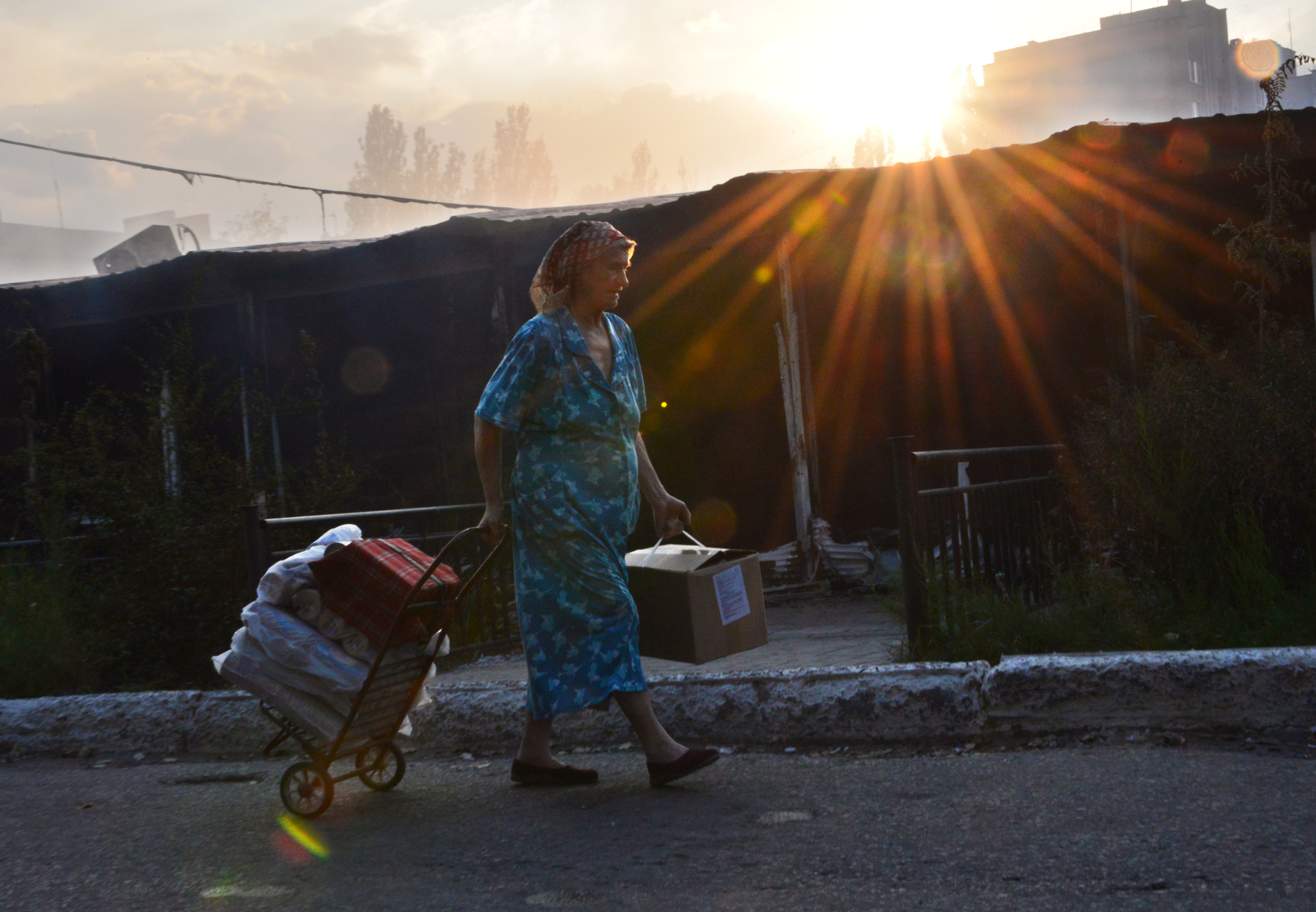 A woman walks by a burning local market after shelling in the town of Yasynuvata, near the rebel stronghold of Donetsk, eastern Ukraine on August 12, 2014.