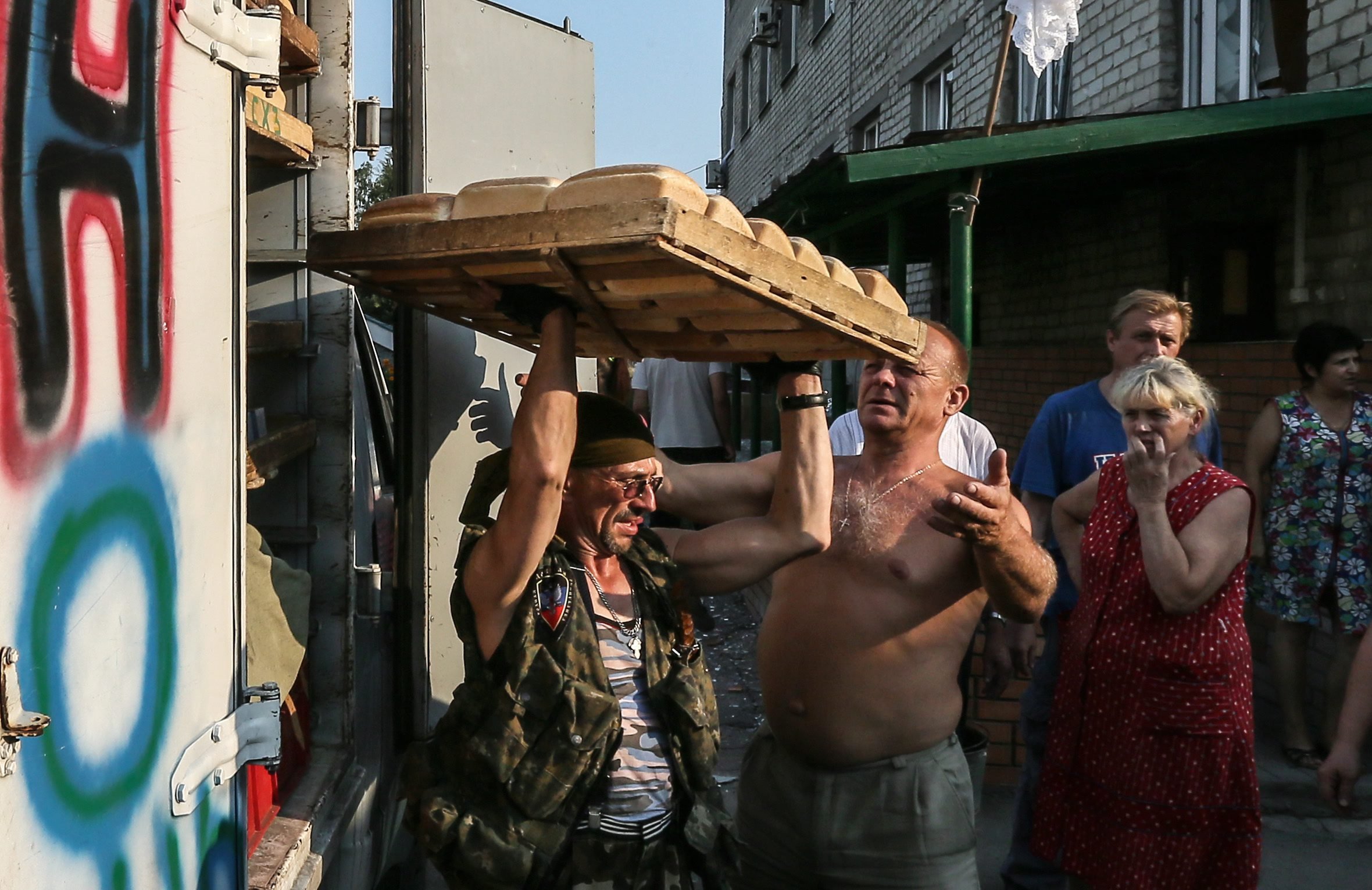 Member of the Donetsk People's Republic militias carry trays with bread for locals hiding in shelters in Ilovaysk 50km from Donetsk, Ukraine on August 14, 2014.