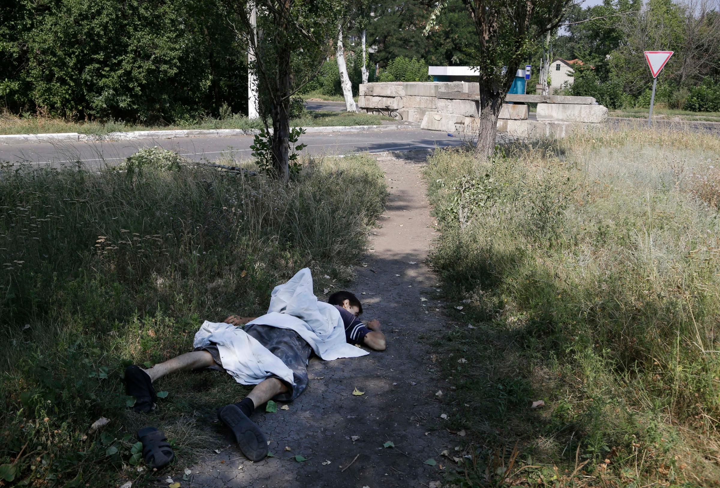 A dead body lies in a street in the city's southwestern Petrovsky district after shelling in Donetsk, eastern Ukraine on August 13, 2014.