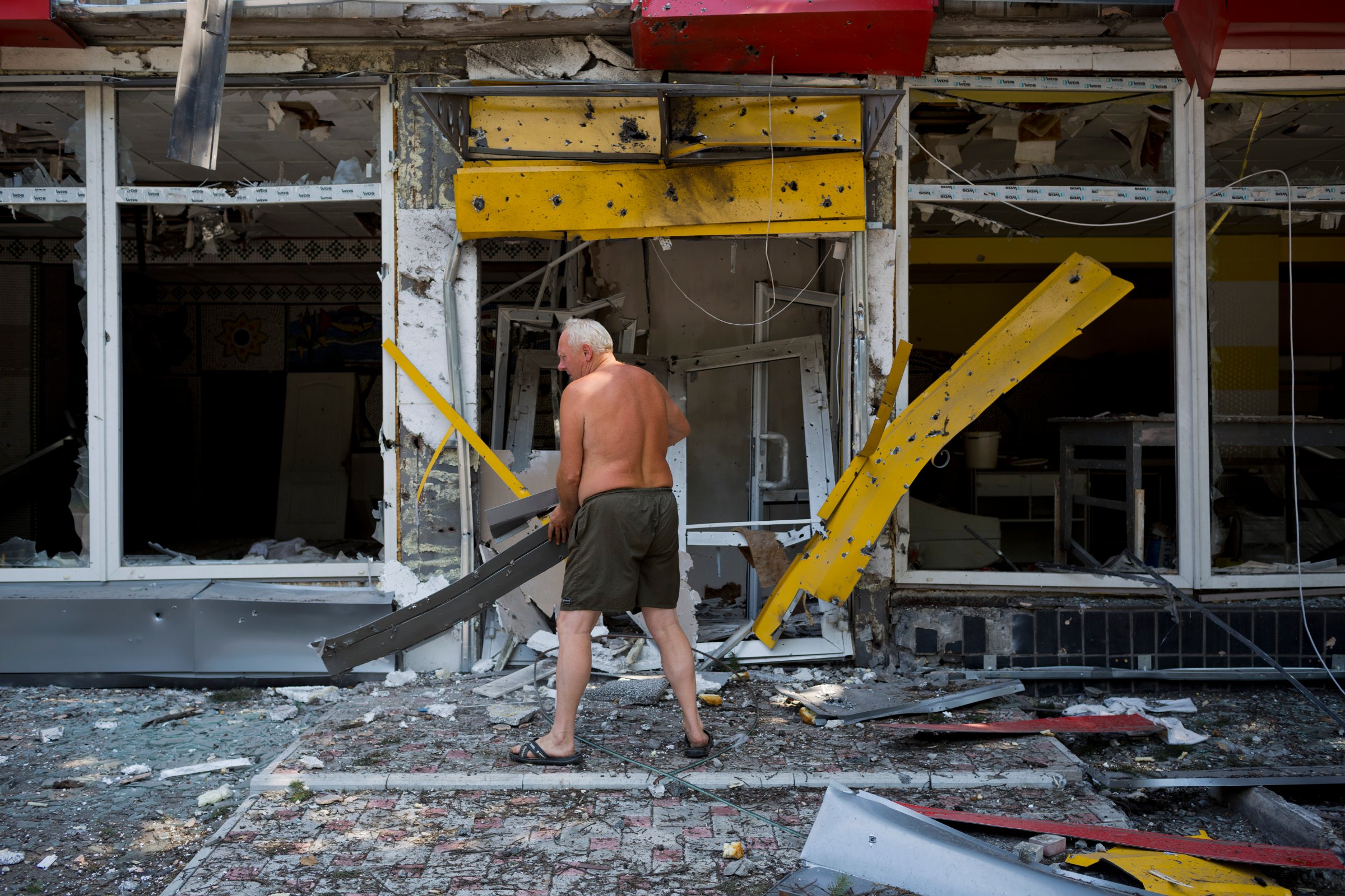 A man clears debris as the Ukrainian army retakes a village from pro-Russian rebels onAugust 13, 2014 in Uglegorsk. Ukraine.