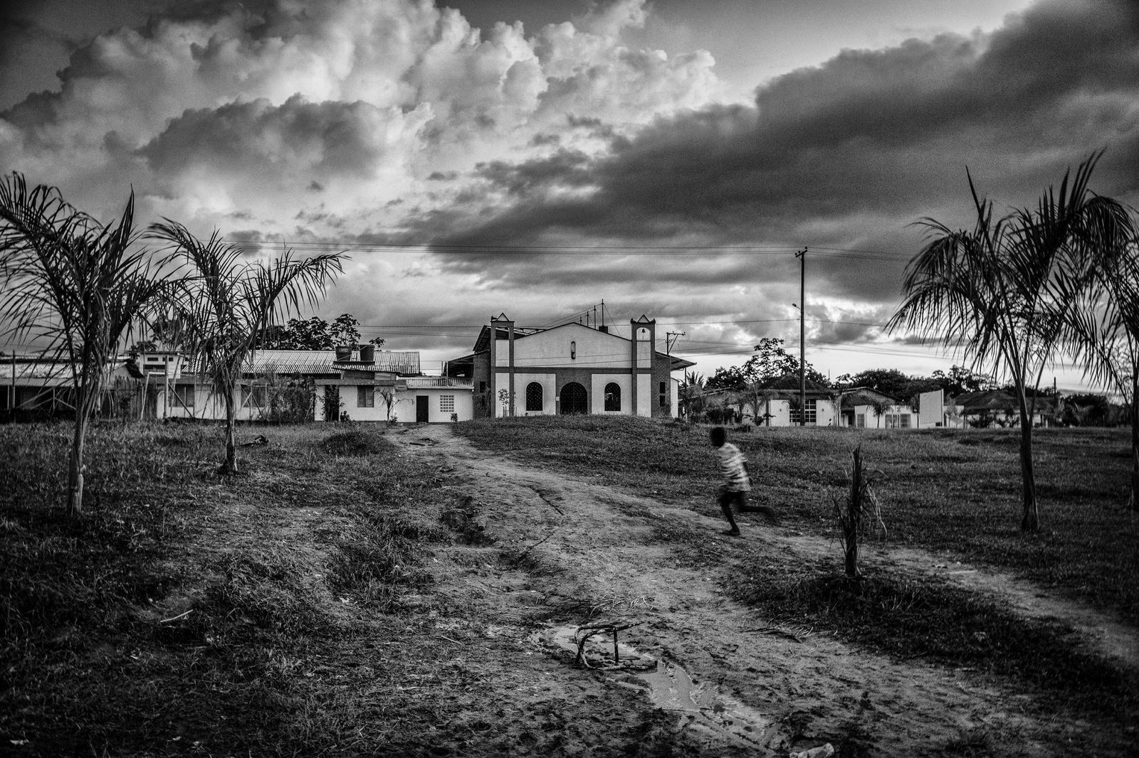 A boy runs through the center of the town of Bella Vista. The town was rebuild in 2010 after it was sieged by clashes between the 36 front faction of FARC and paramilitaries. Bella Vista, Colombia. July 18, 2013.