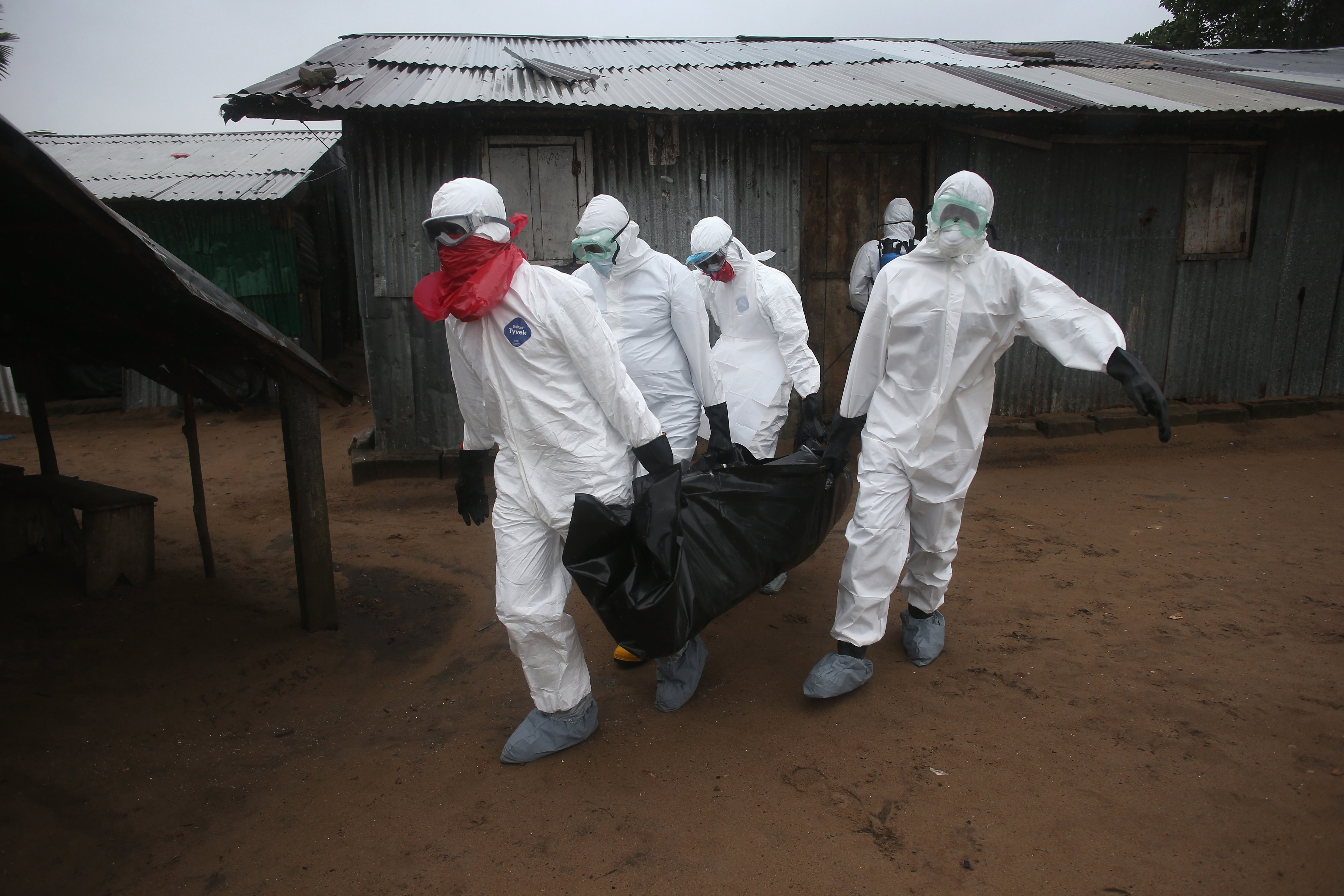 A Liberian burial team wearing protective clothing retrieves the body of a 60-year-old Ebola victim from his home on August 17, 2014 near Monrovia, Liberia. 