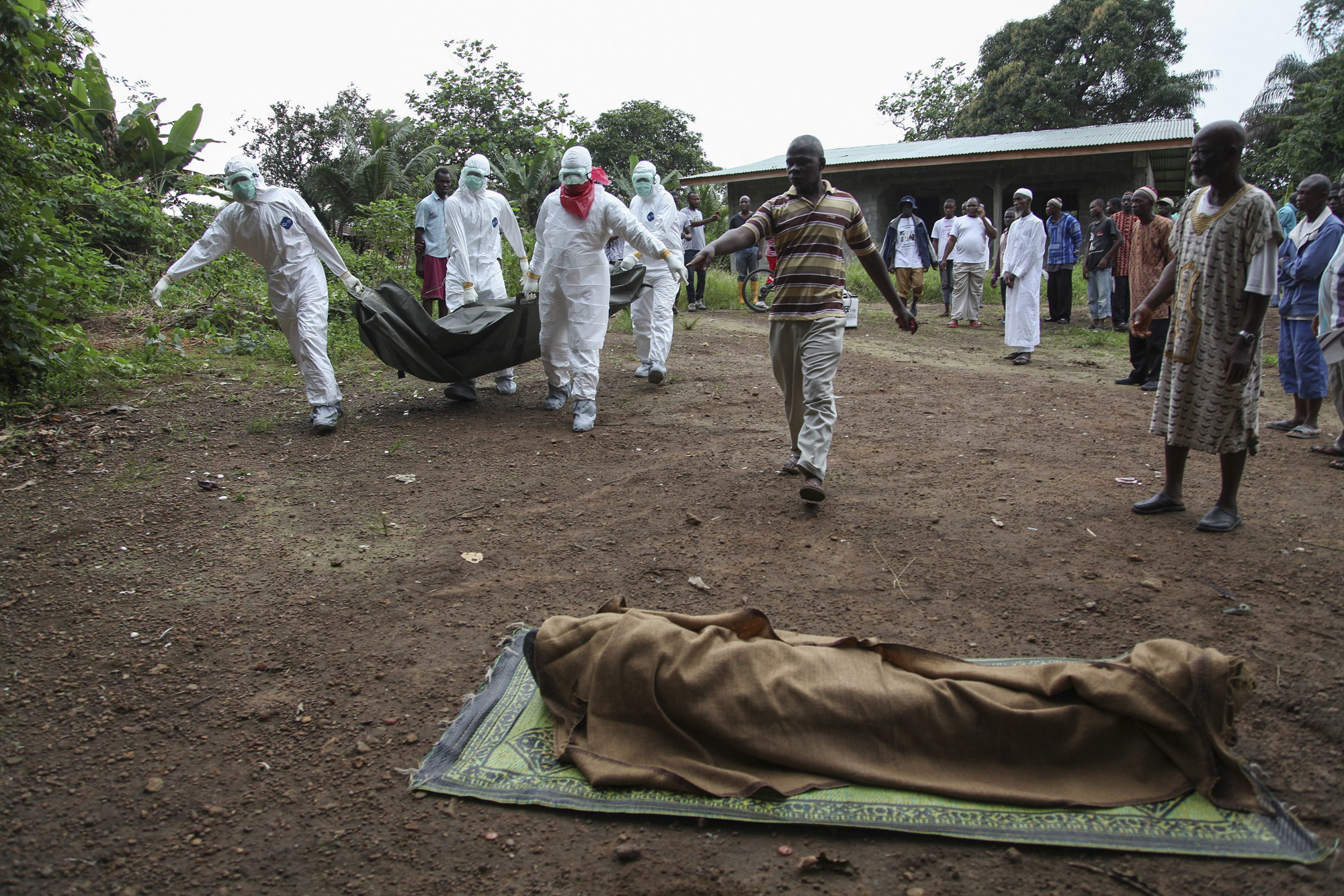 Liberian nurses carry the body of an Ebola victim on the way to bury them in the Banjor Community on the outskirts of Monrovia, Liberia, Aug. 6, 2014.