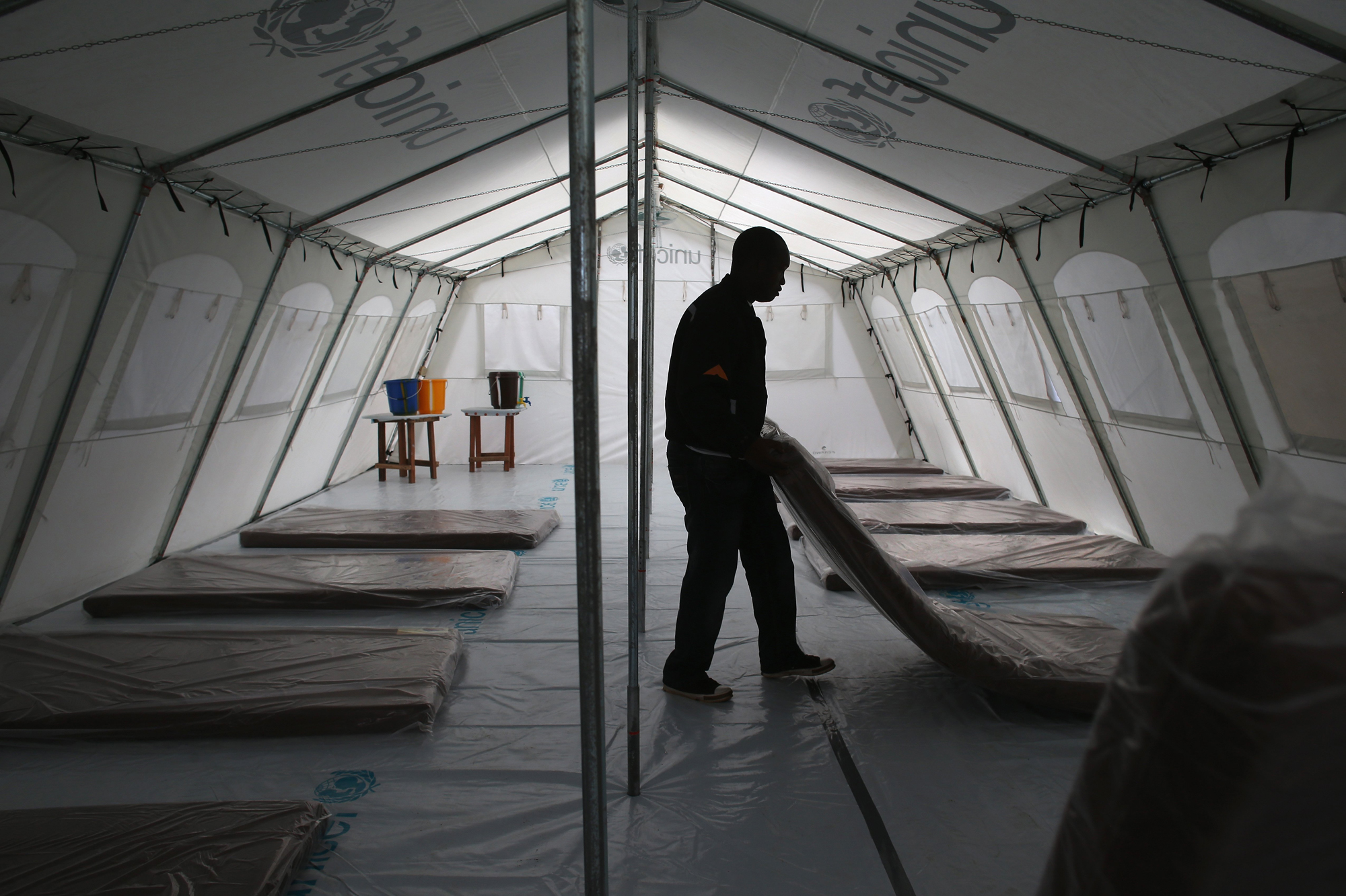 Workers prepare the new Doctors Without Borders (MSF), Ebola treatment center on Aug. 17, 2014 near Monrovia, Liberia. Tents at the center were provided by UNICEF.