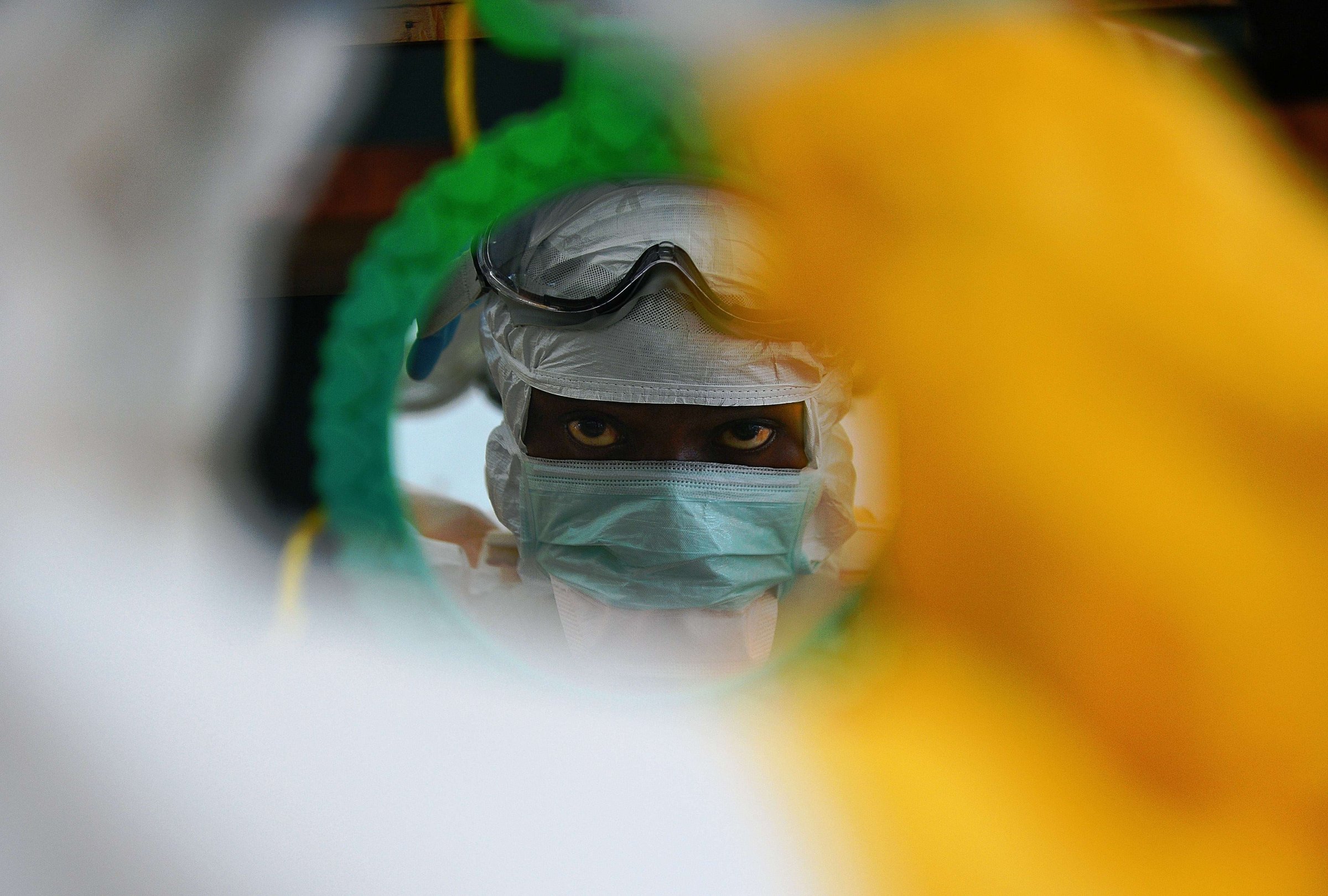 An MSF medical worker checks their protective clothing in a mirror at an MSF facility in Kailahun, Sierra Leone on August 15, 2014.