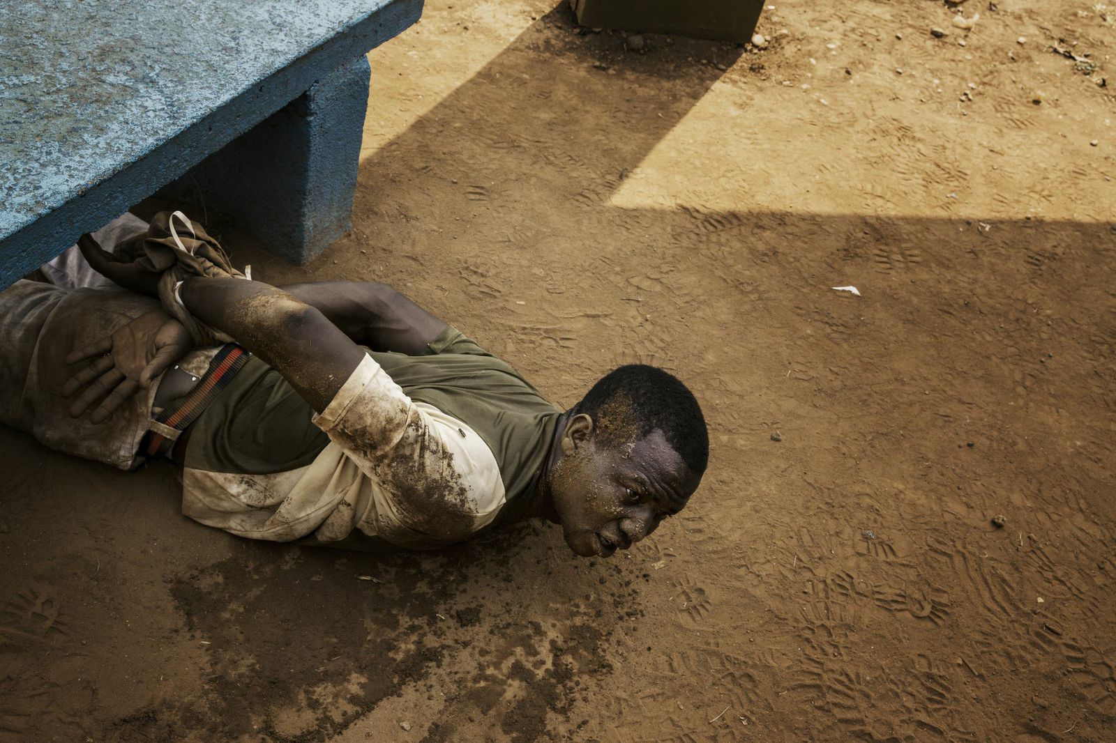 A man arrested by MISCA (Mission Internationale de Soutien a la Centrafrique Sous Conduite Africaine) soldiers lies on the ground with his wrists tied. He was found with a grenade in a pocket. Bangui, Central African Republic.