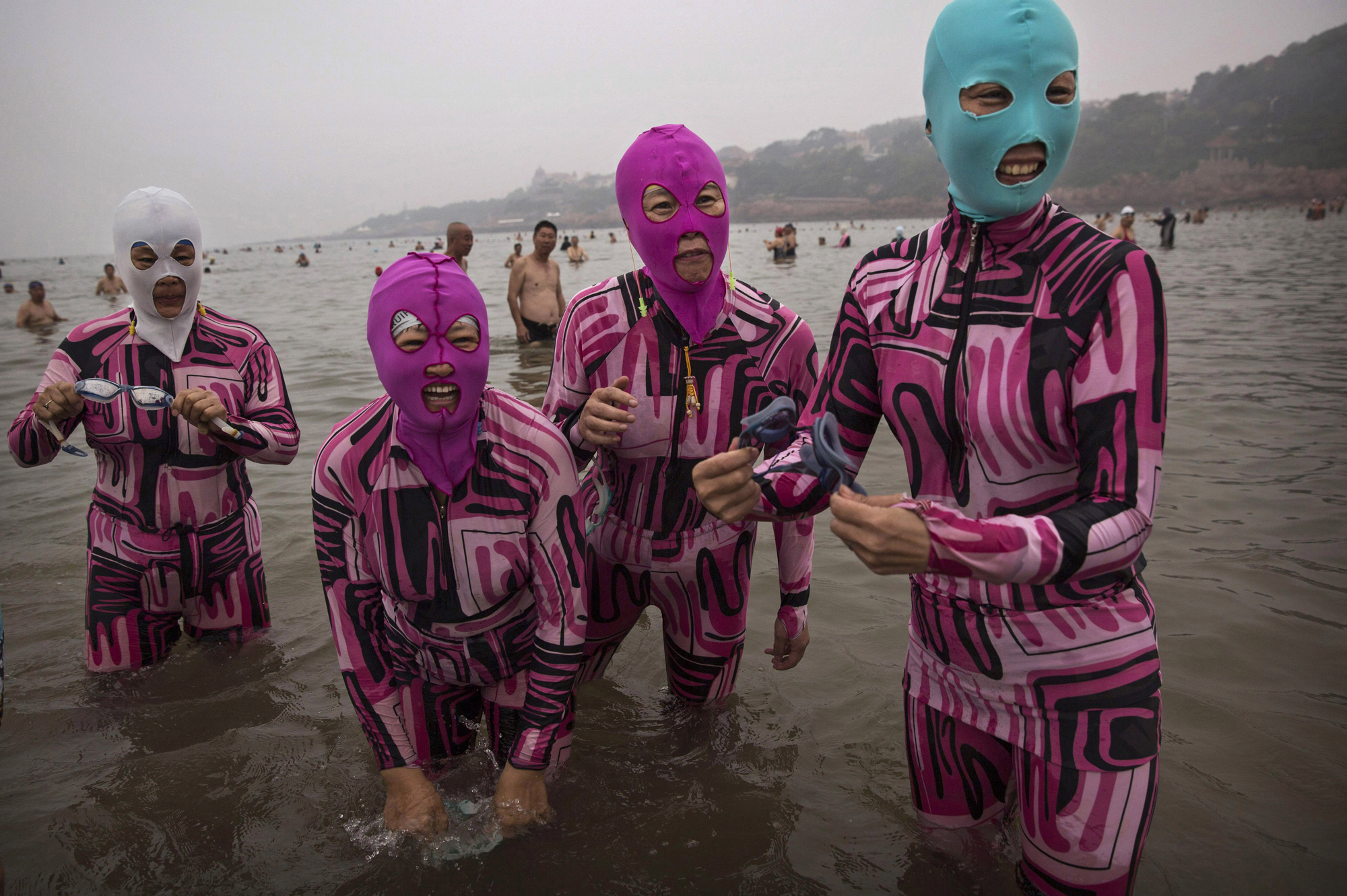 Chinese women wear face-kinis as they stand in the water on Aug. 20, 2014 on the Yellow Sea in Qingdao, China.