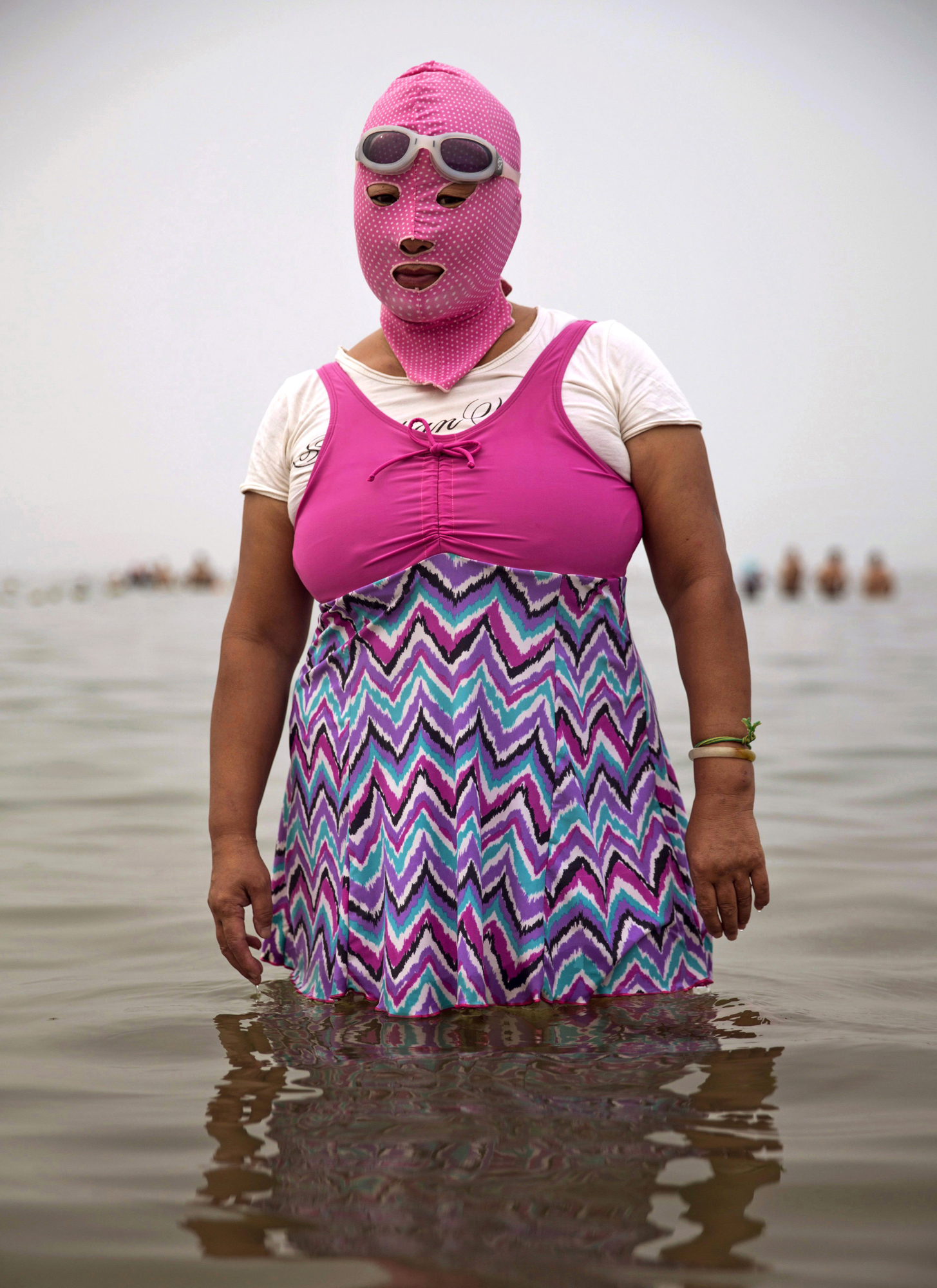 A woman wears a facekini as she poses on Aug. 21, 2014, in the Yellow Sea in Qingdao.