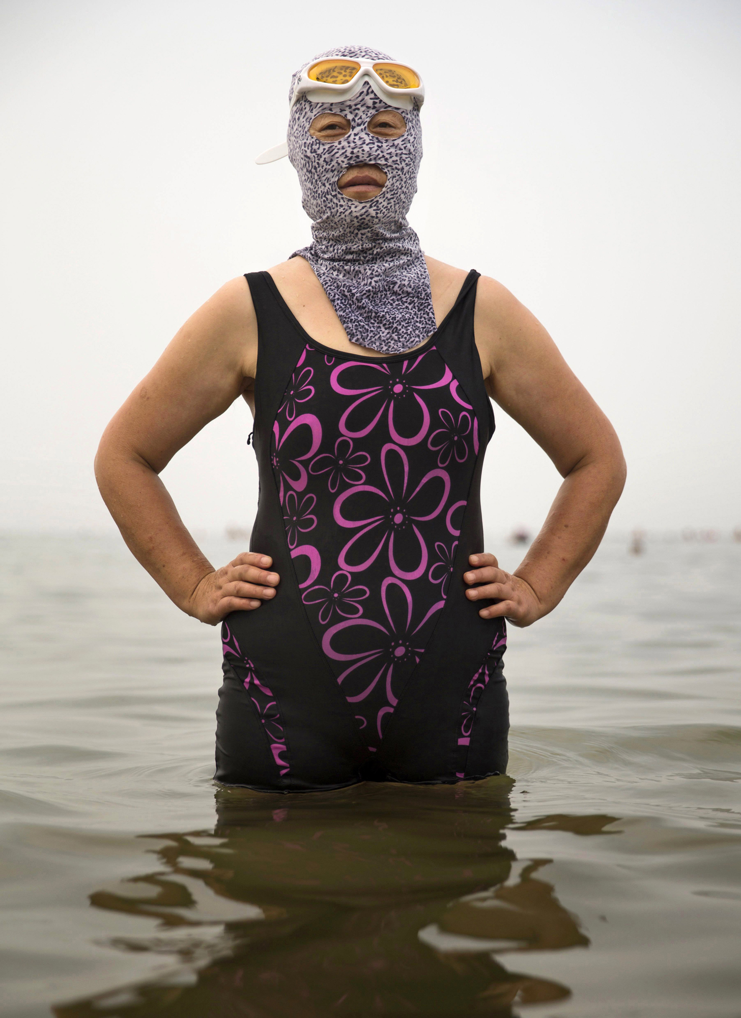 A woman wears a facekini as she poses on Aug. 21, 2014, in the Yellow Sea in Qingdao.