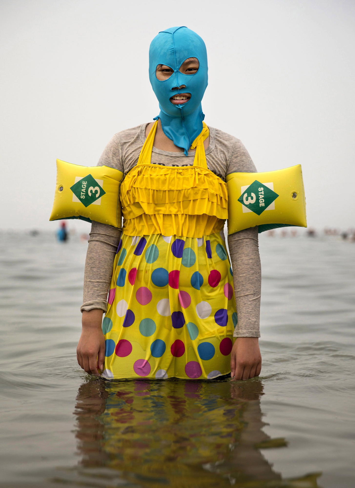 A woman wears a facekini as she poses on Aug. 21, 2014, in the Yellow Sea in Qingdao, China.