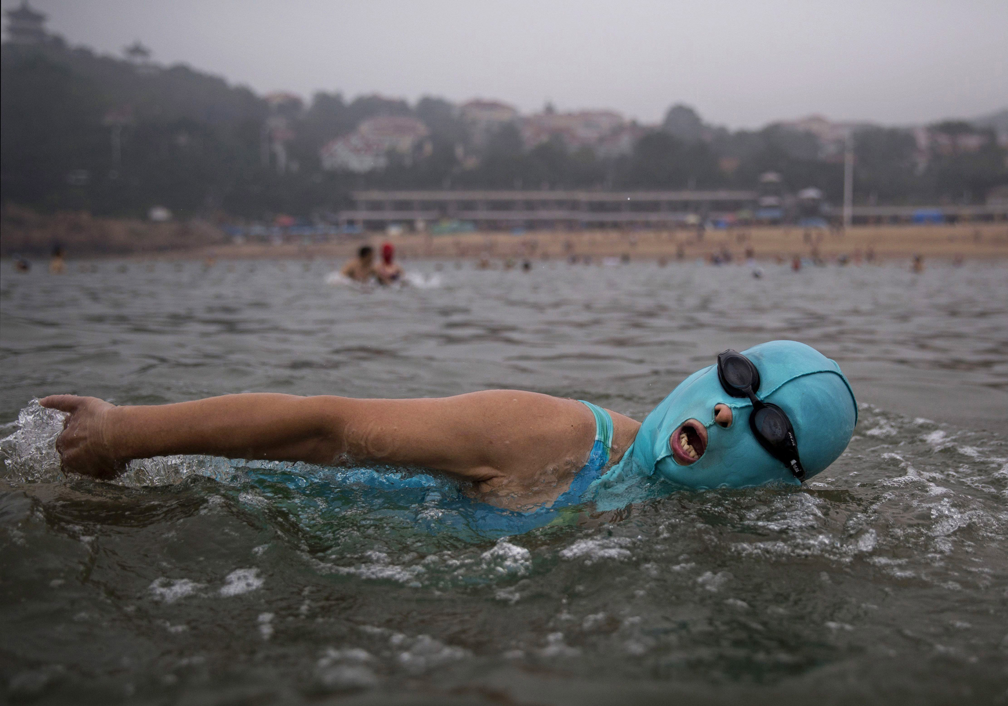 A woman wears a facekini as she swims on Aug. 20, 2014, on the Yellow Sea in Qingdao.
