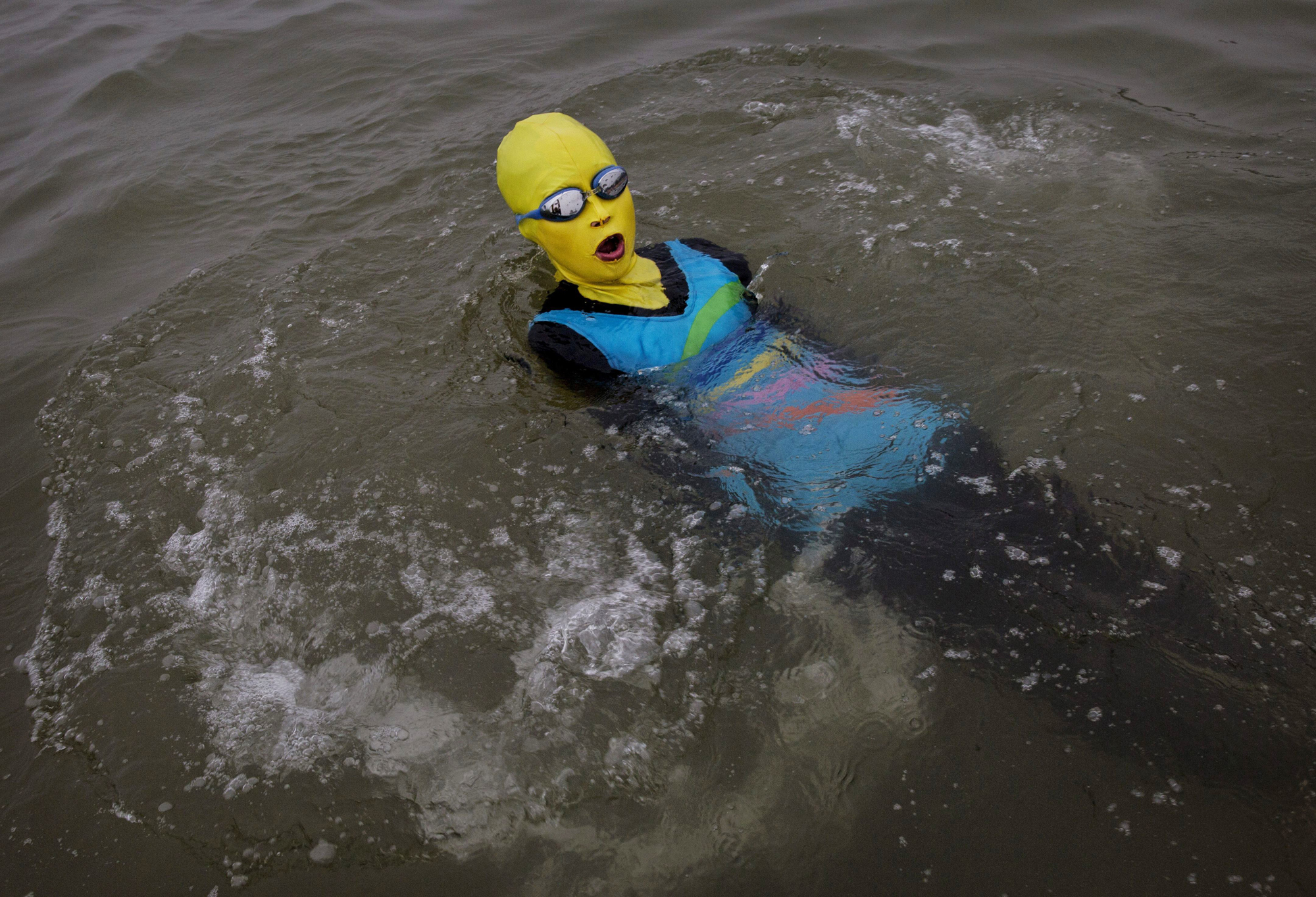 A Chinese woman wears a face-kini as she swims on August 20, 2014 on the Yellow Sea in Qingdao.