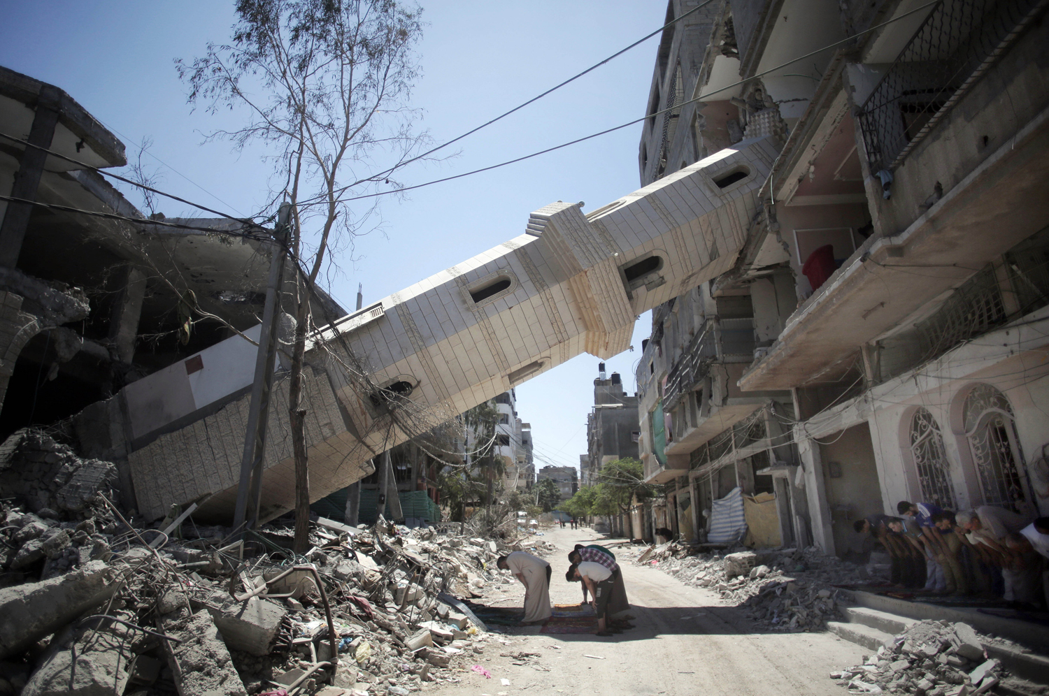Aug. 8, 2014. Palestinians attend Friday noon prayers in the shadow of a toppled minaret at a mosque in Gaza City.