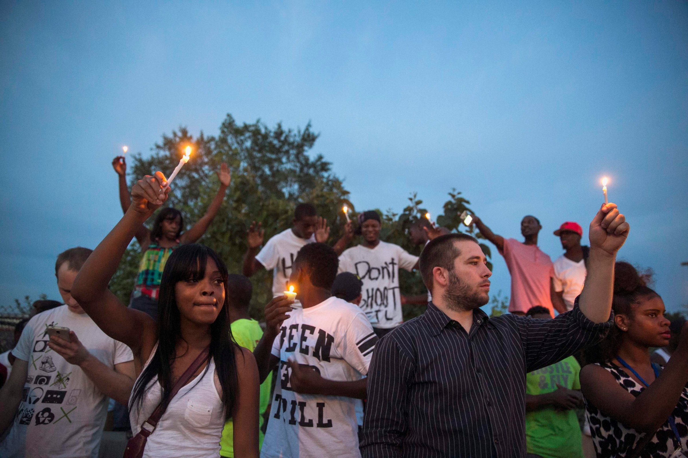Protesters light candles as they take part in a peaceful demonstration, as communities react to the shooting of Michael Brown in Ferguson, Missouri August 14, 2014.
