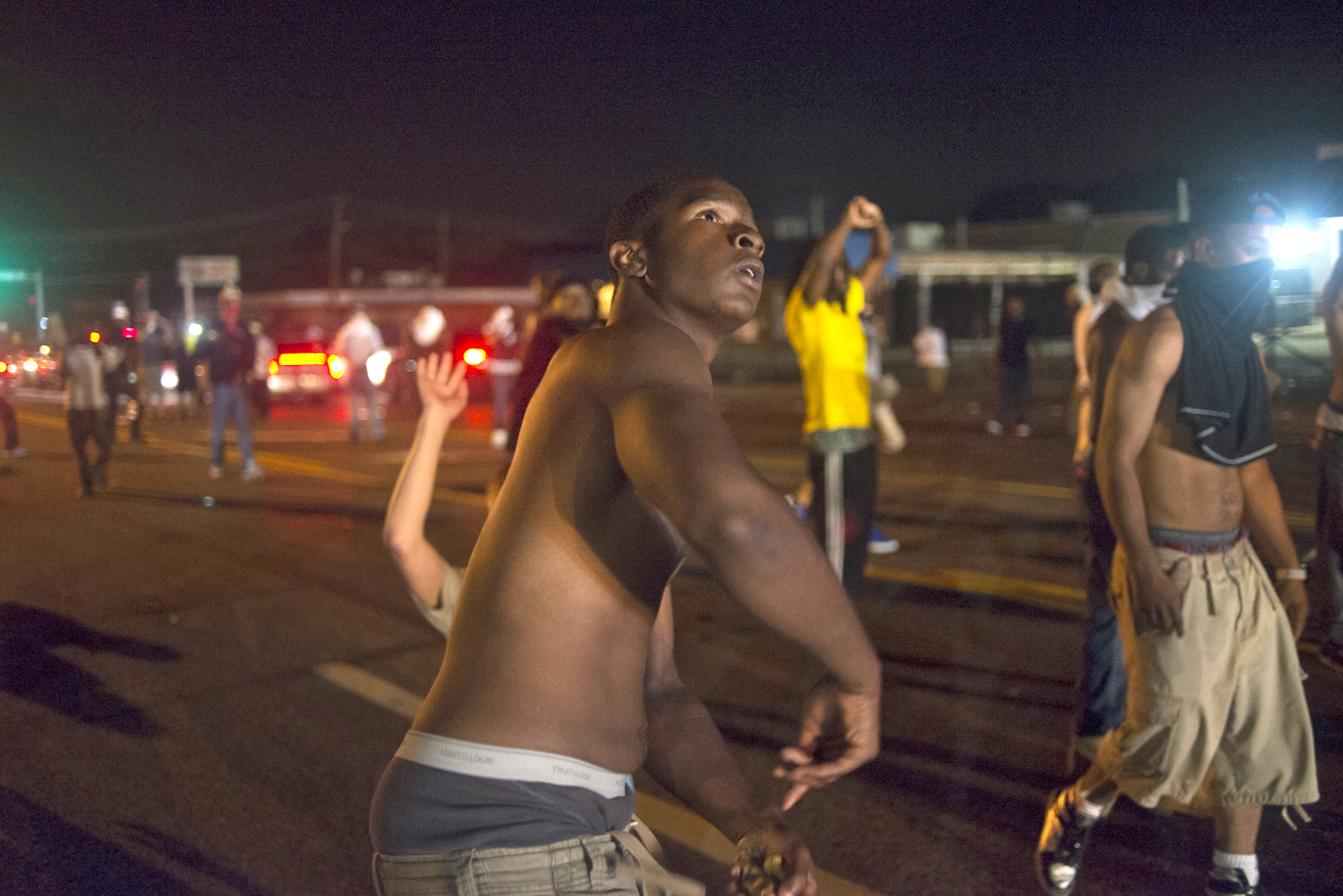 A protestor retaliates against police during violent clashes in Ferguson, Mo. on Aug. 17, 2014. (Jon Lowenstein—Noor for TIME)