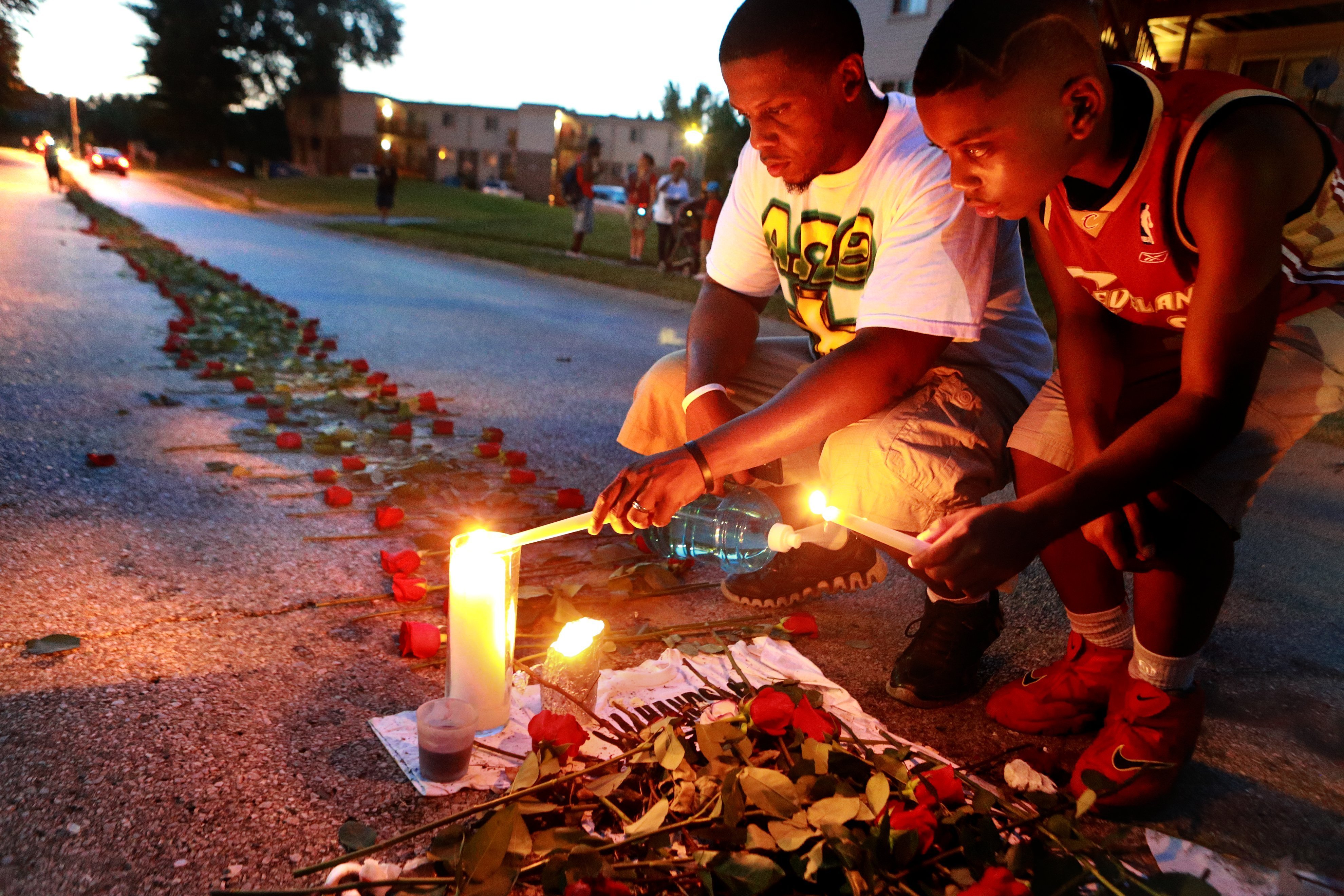 Theo Murphy (left) of Florissant and his brother Jordan Marshall light candles, at a memorial on Canfield Drive where unarmed teen Michael Brown was fatally shot, Aug. 21, 2014 in Ferguson, Mo. (Christian Gooden—St. Louis Post-Dispatch/Polaris)