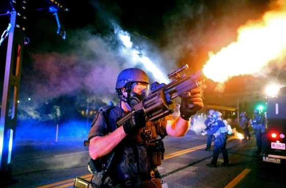 Police fire tear gas in the direction of where bottles were thrown from crowds gathered near the QuikTrip on W. Florissant Avenue on Aug. 18, 2014.