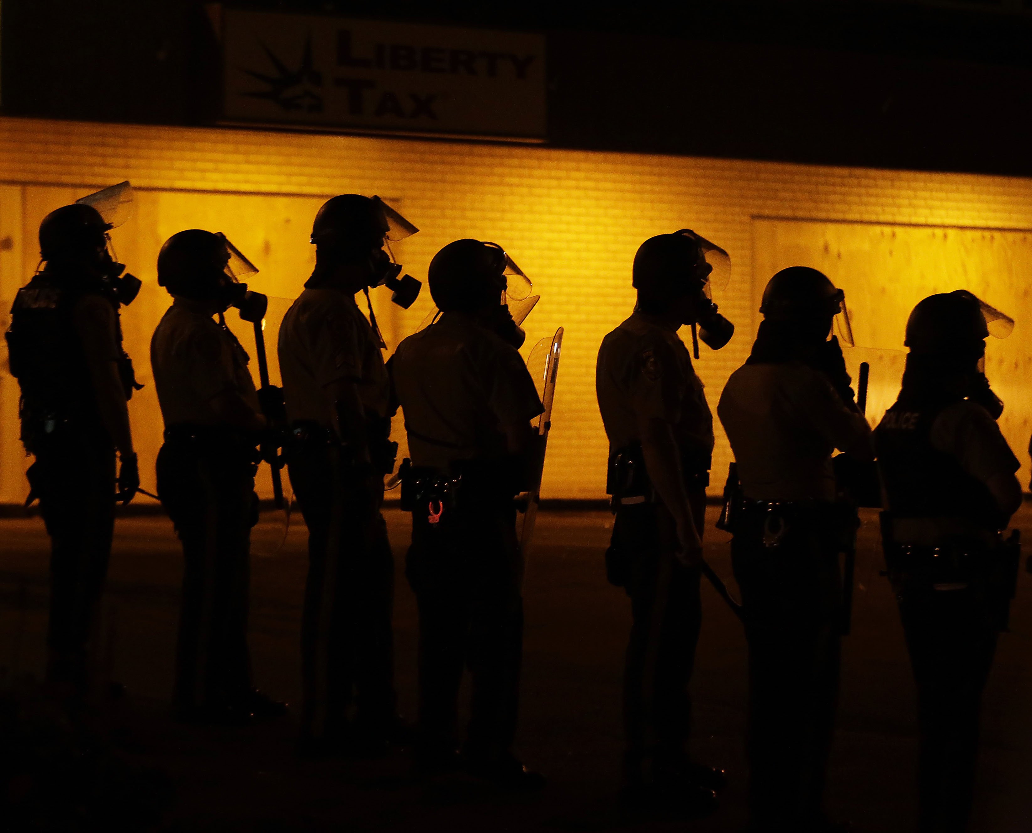 Police wait to advance after tear gas was used to disperse a crowd in Ferguson, Mo. on Aug. 17, 2014. (Charlie Riedel—AP)