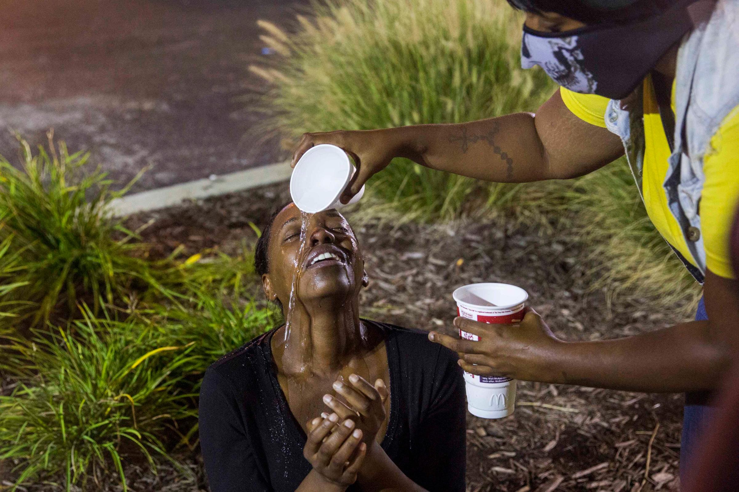 Protesters react to the effects of tear gas which was fired at demonstrators reacting to the shooting of Michael Brown in Ferguson, Missouri